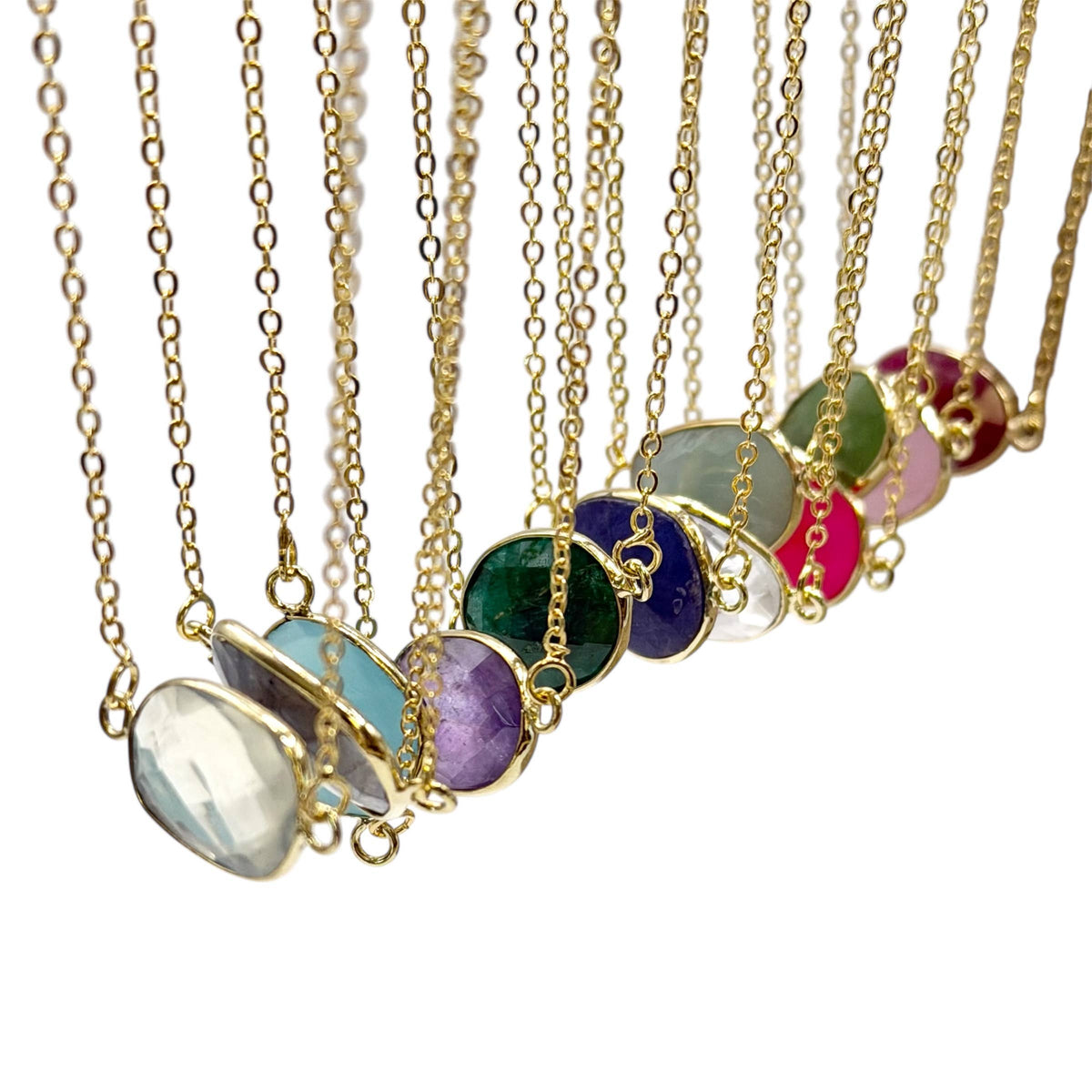 Set of gold necklaces with colorful pendant stones on a white background