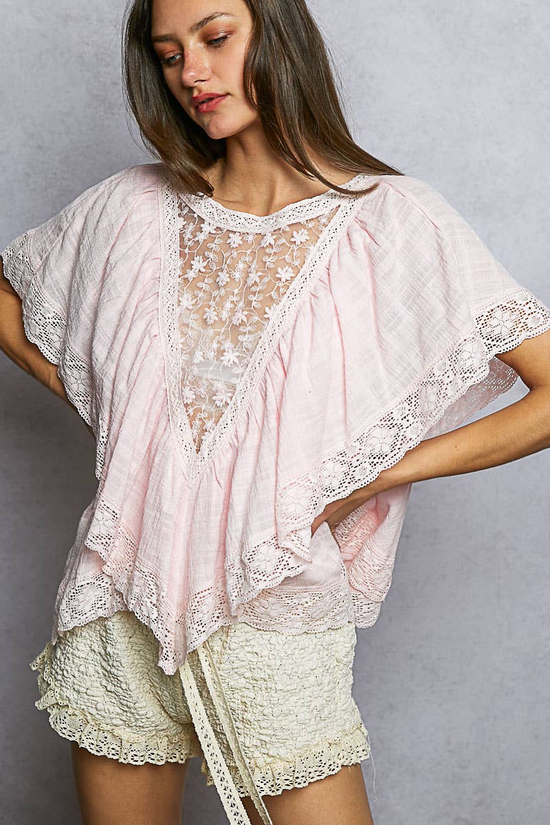 Model wearing pink reversible boho top with sheer embroidered front panel, layered V-ruffles, and lace-trimmed sleeves