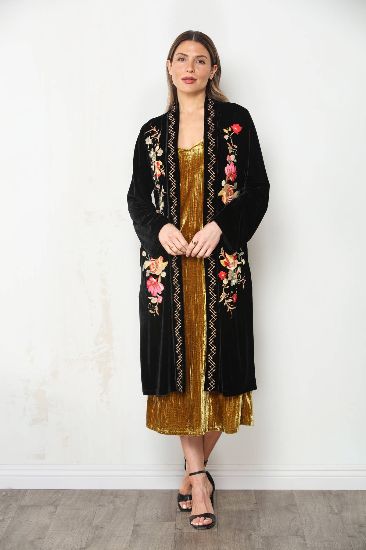 Full-length front view of Midnight Bloom black embroidered velvet duster with gold dress and black ankle-strap heels.