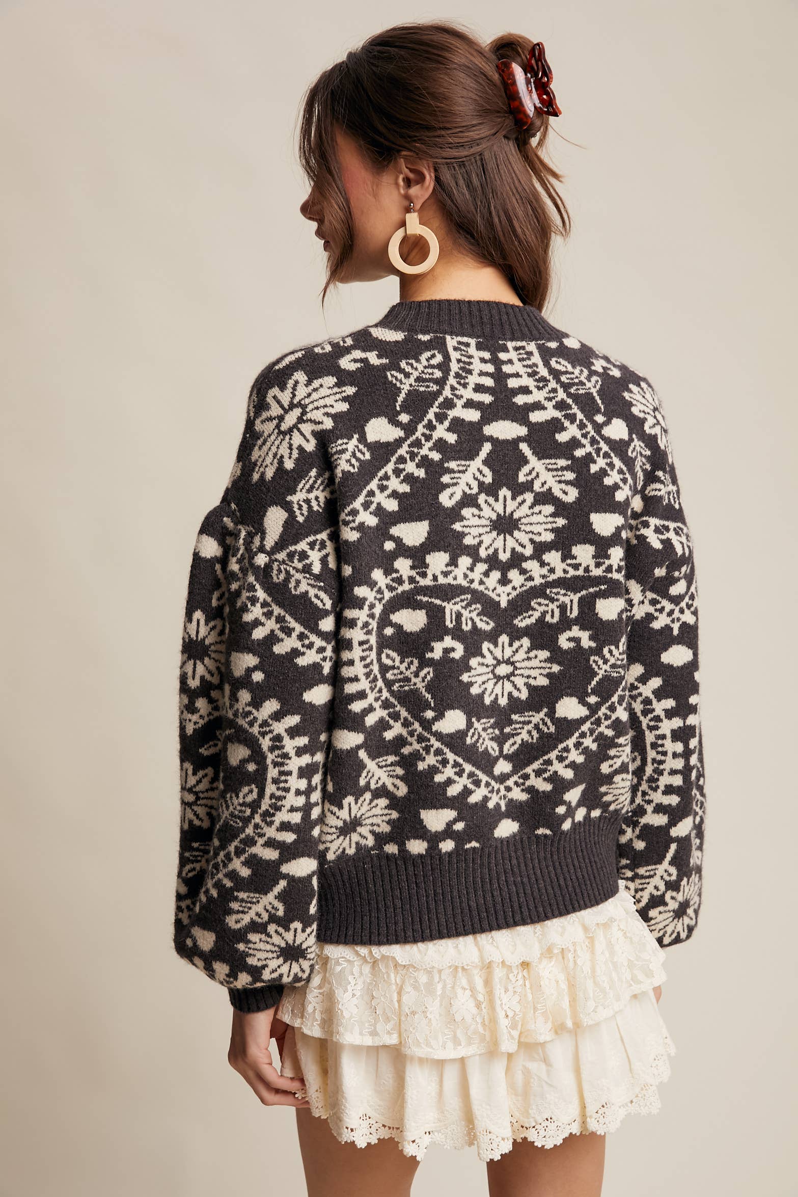 Back view- Charcoal crewneck sweater with cream floral heart–motif jacquard, puff sleeves, and ribbed cuffs and hem.