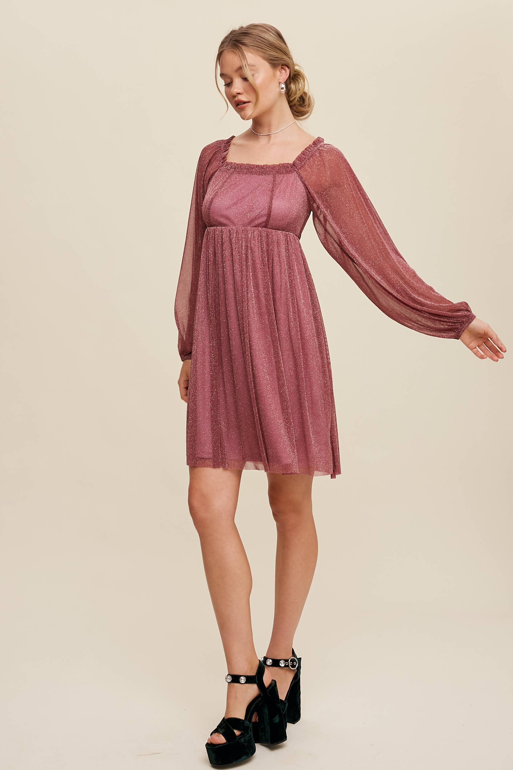 Model wearing a mauve shimmer mini dress with long sheer sleeves, square neckline, and flowy A-line silhouette — romantic sparkle party dress