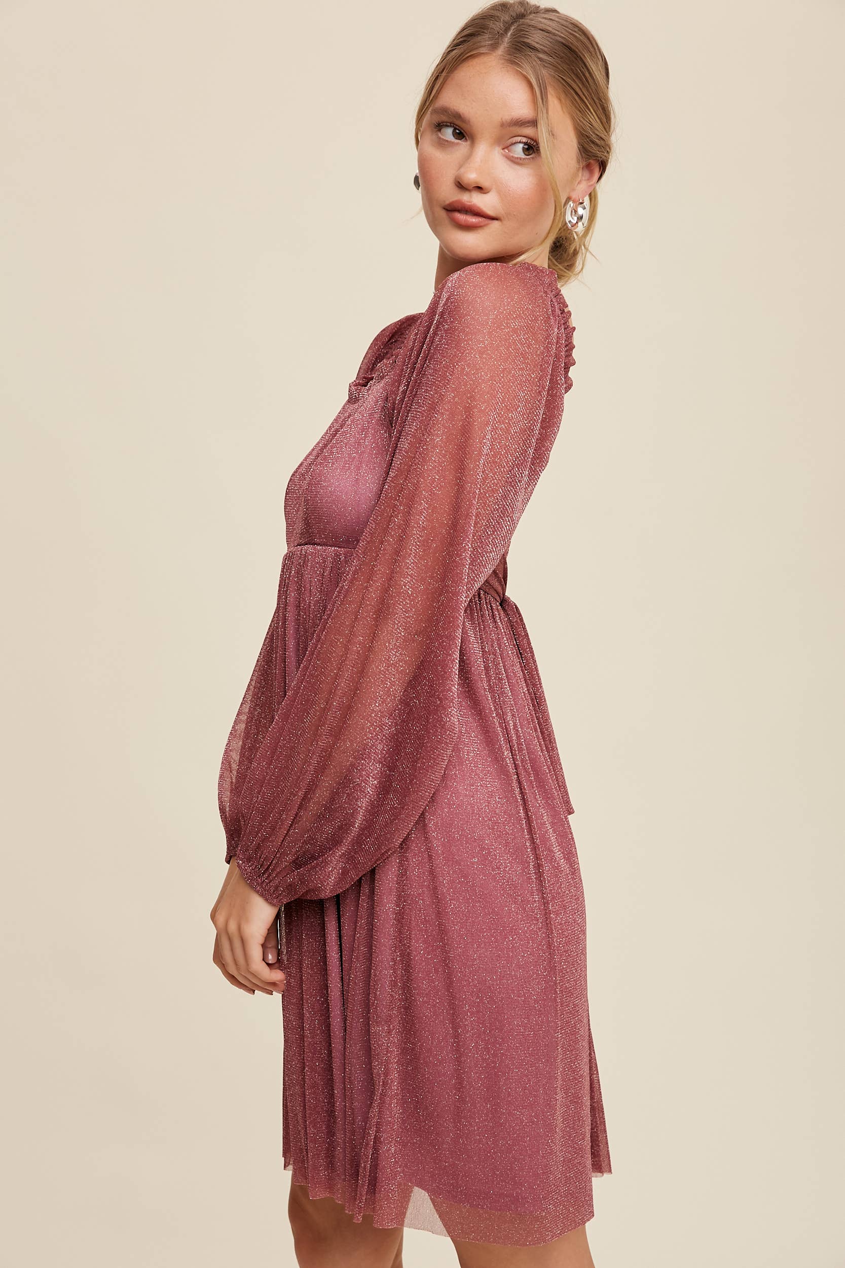 Model wearing a mauve shimmer mini dress with long sheer sleeves, square neckline, and flowy A-line silhouette — romantic sparkle party dress