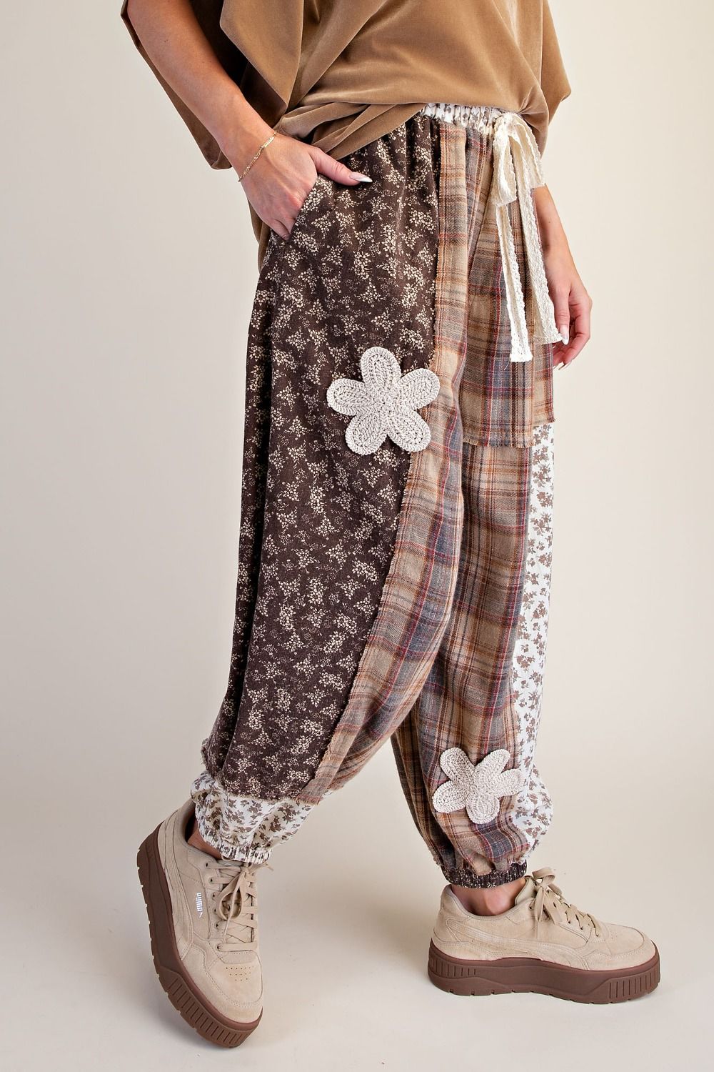 Side view Model wearing THISTLE & THREAD patchwork joggers with mixed floral and plaid panels