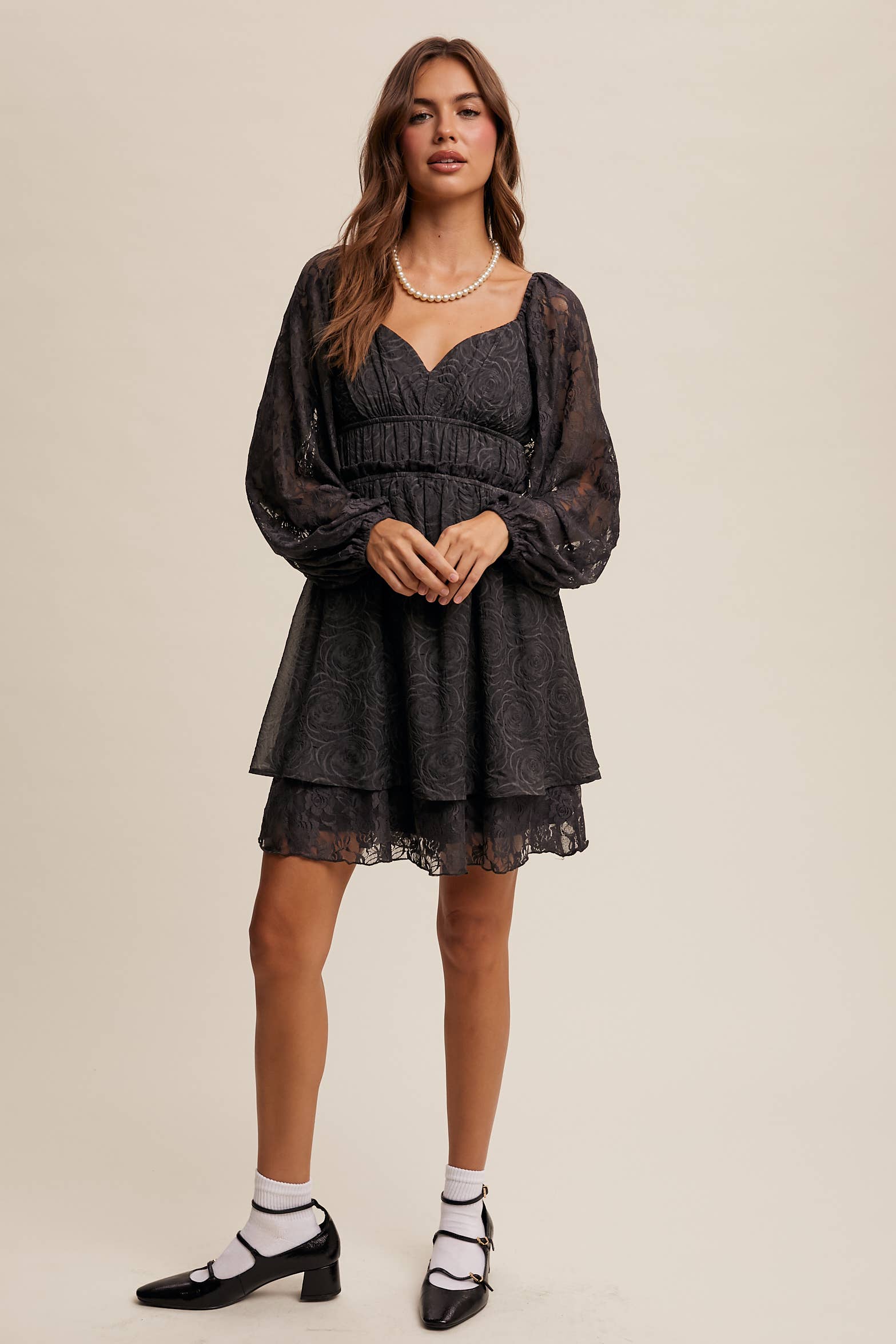 Model wearing The Midnight Lace Dress with sweetheart neckline and sheer lace sleeves