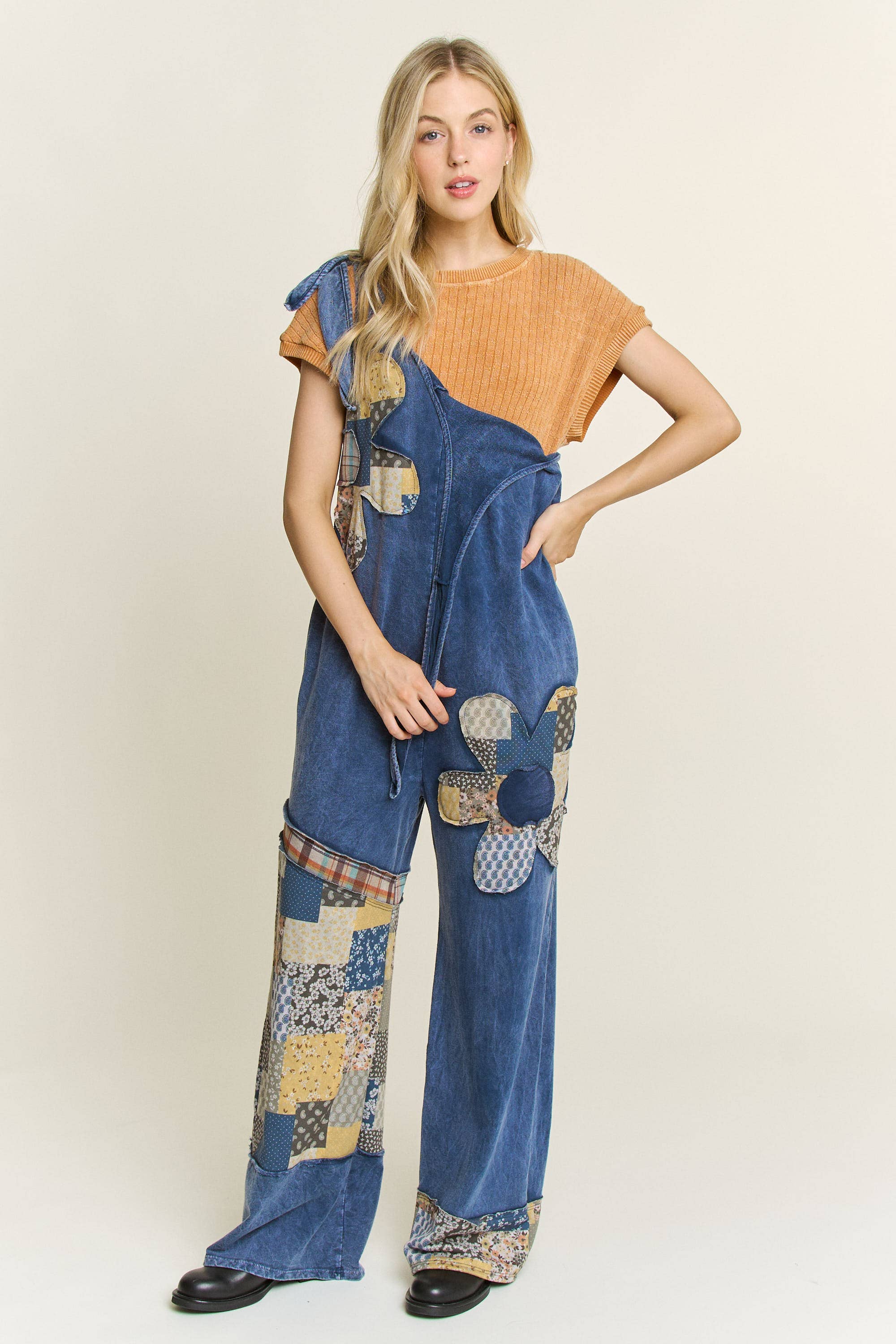 Off the shoulder Woman wearing boho patchwork mineral-wash jumpsuit in navy with daisy appliqués and wide legs