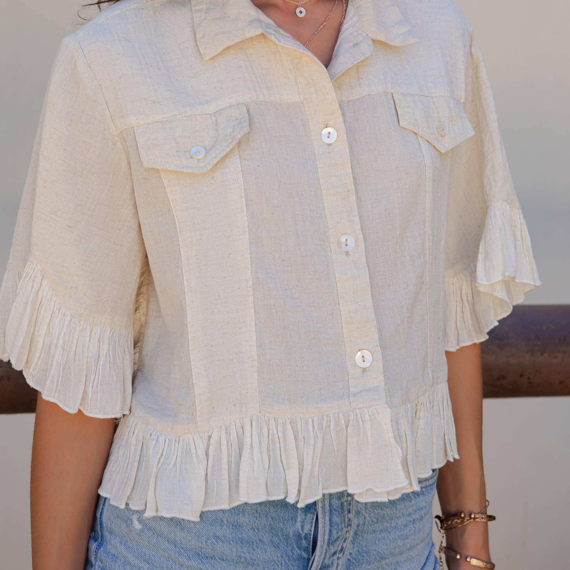 The Rebel Cropped Denim Shirt - close-up of ruffled hem and textured fabric construction