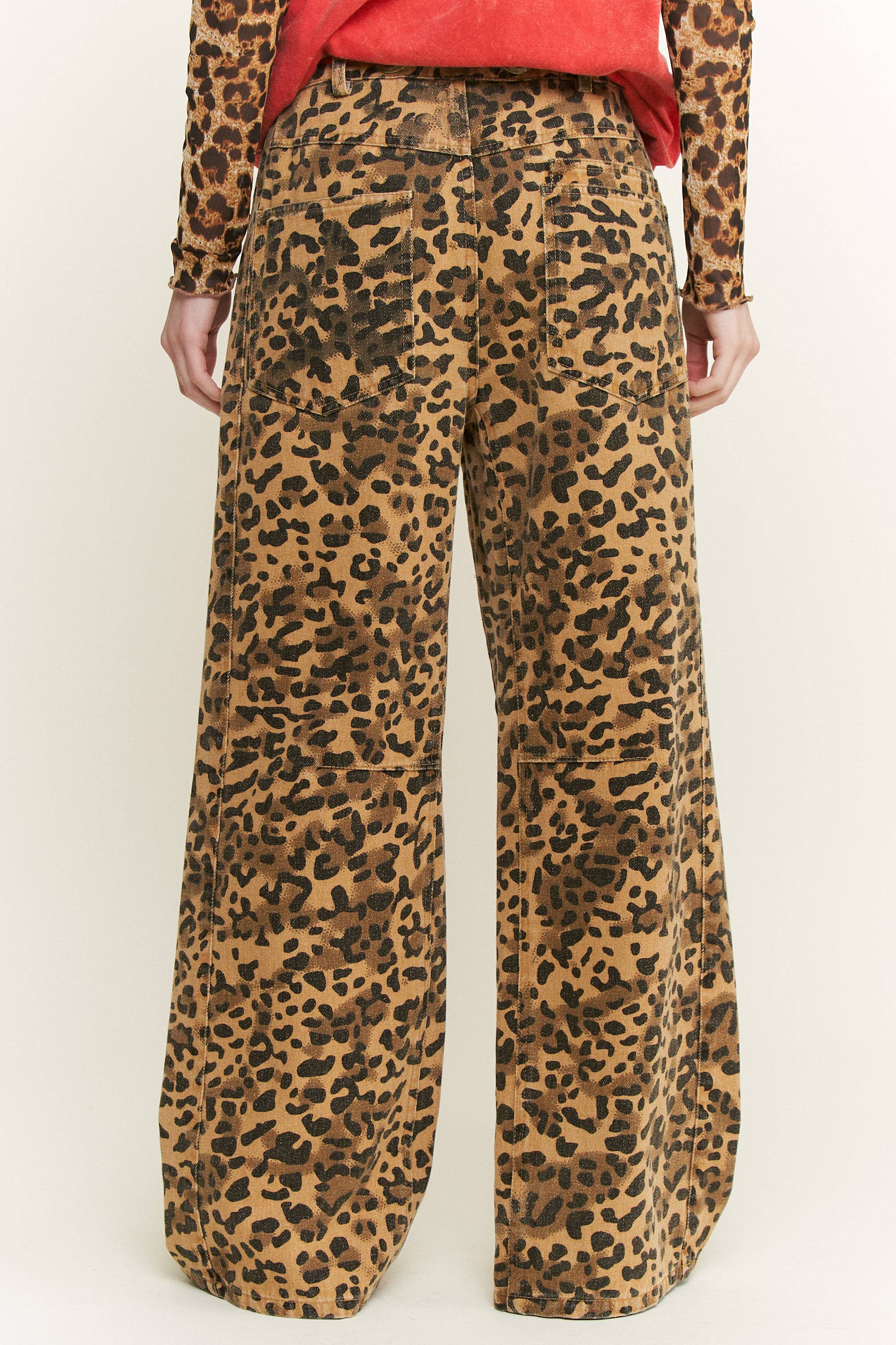 Back view of women’s leopard-print wide-leg pants showing dual patch pockets and relaxed drape.