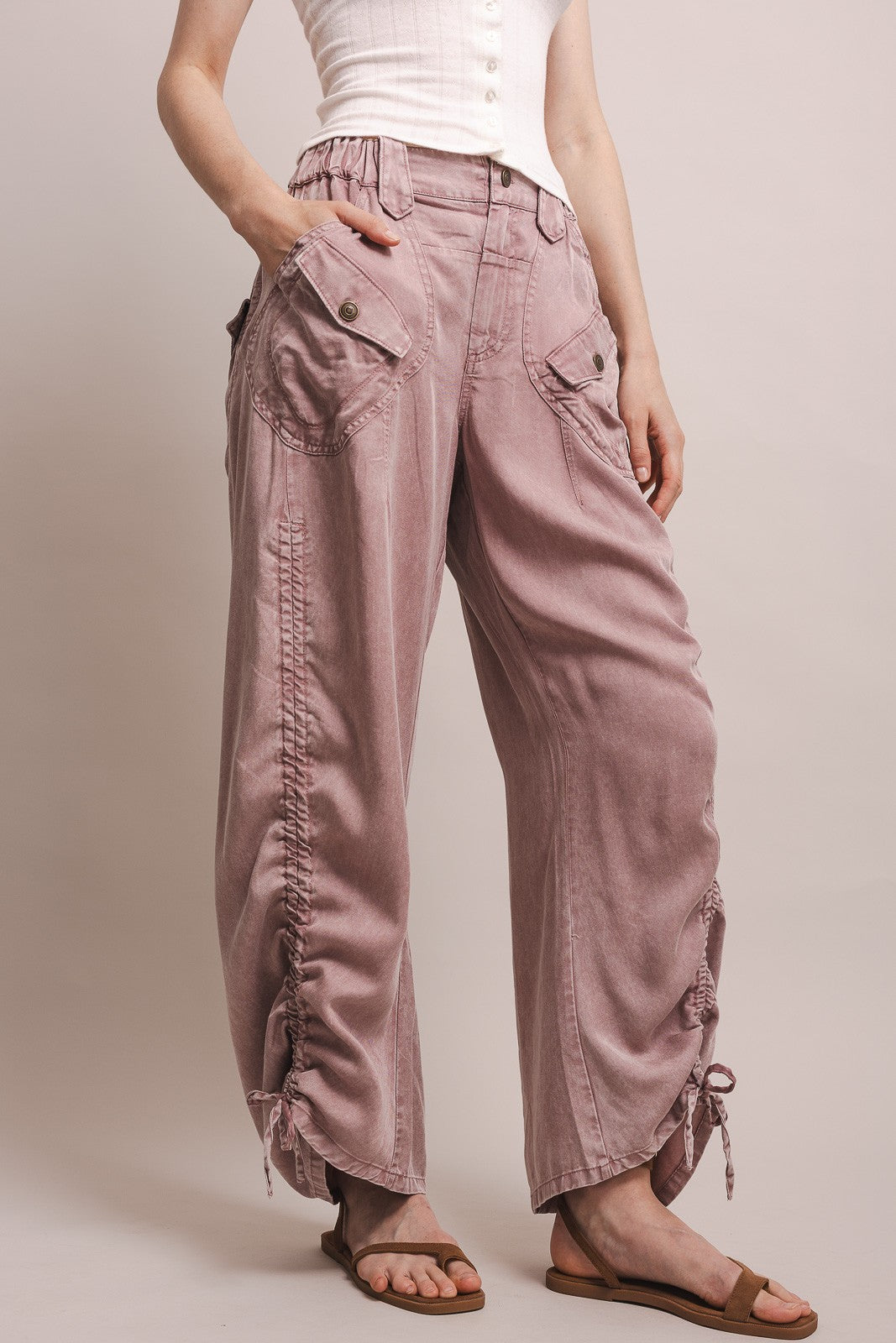 Person wearing pink cargo pants on a plain background