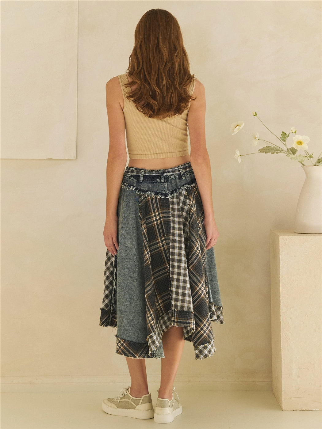 Back view of a washed denim and plaid patchwork draped midi skirt