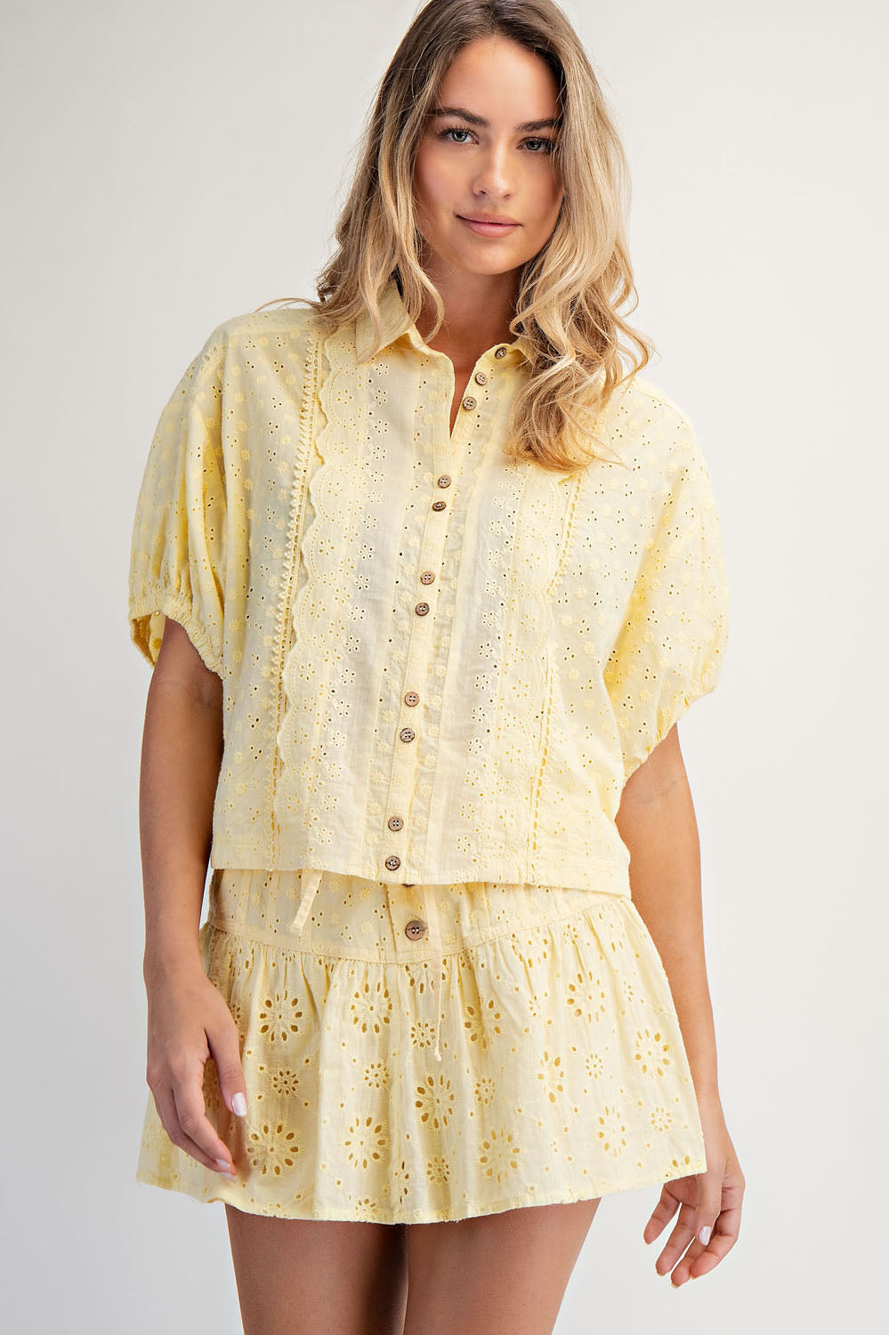 Woman wearing a yellow lace outfit on a plain background