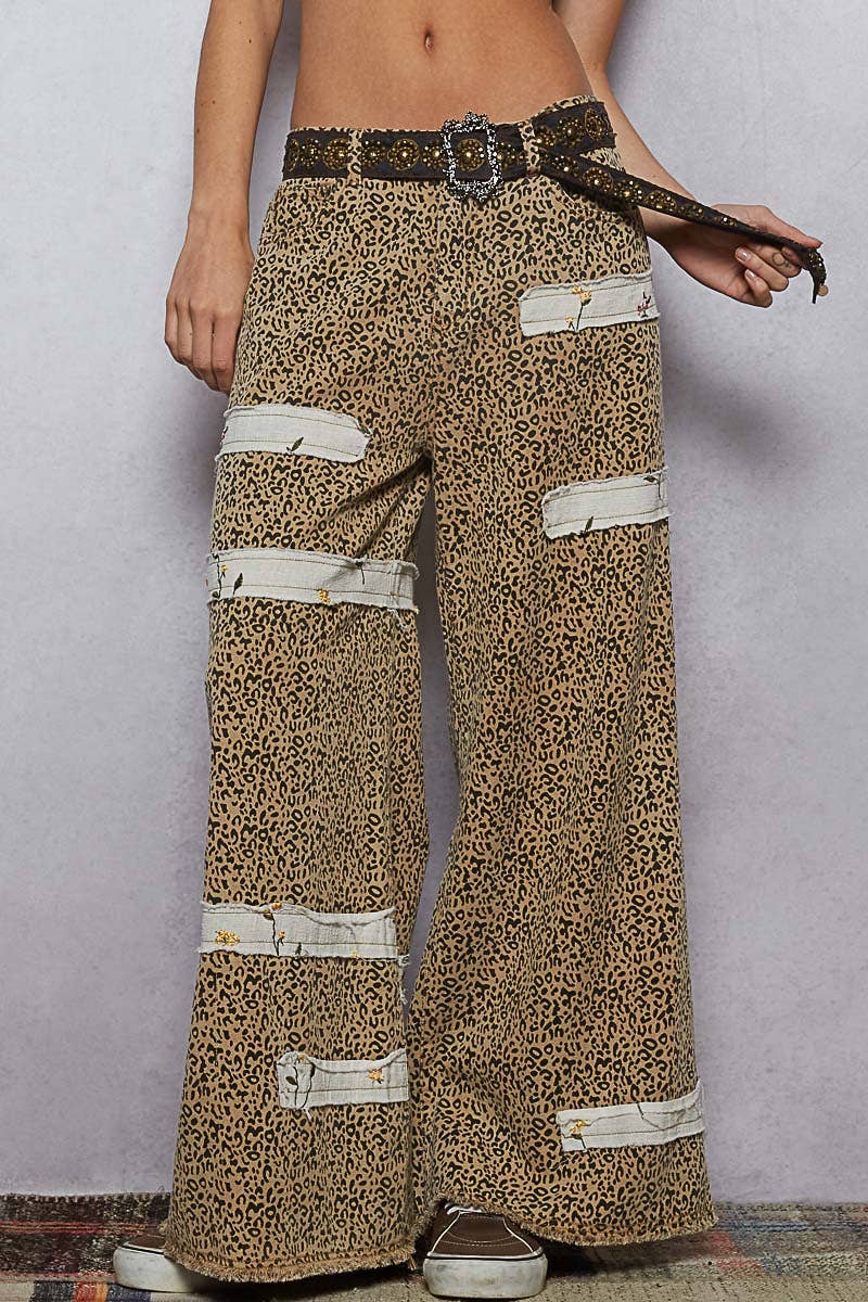 Fashion belt featuring bold gold studs and decorative buckle, styled with patterned jeans.