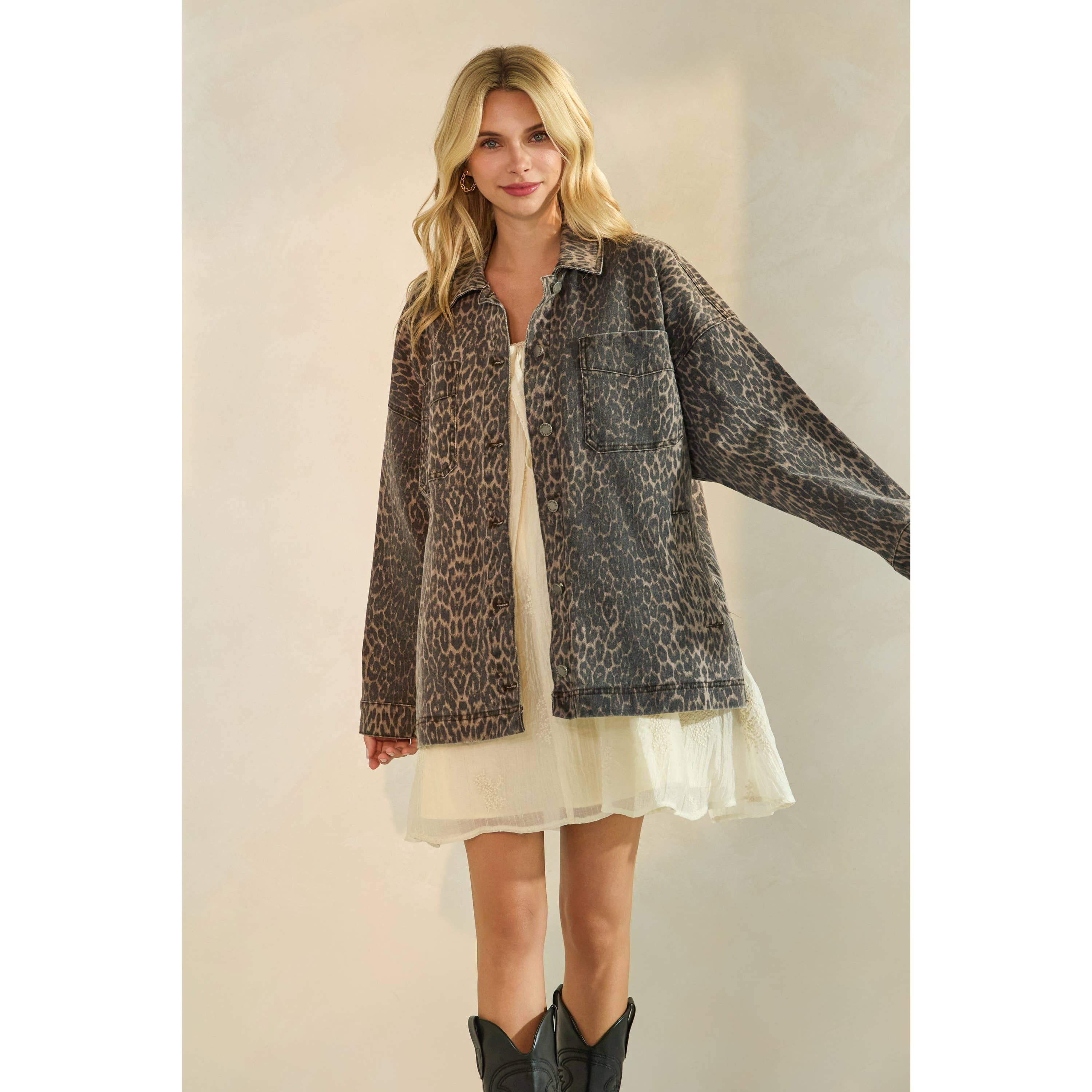 Oversized camouflage print jacket with front pockets and button closure, styled over a white tiered mini dress.