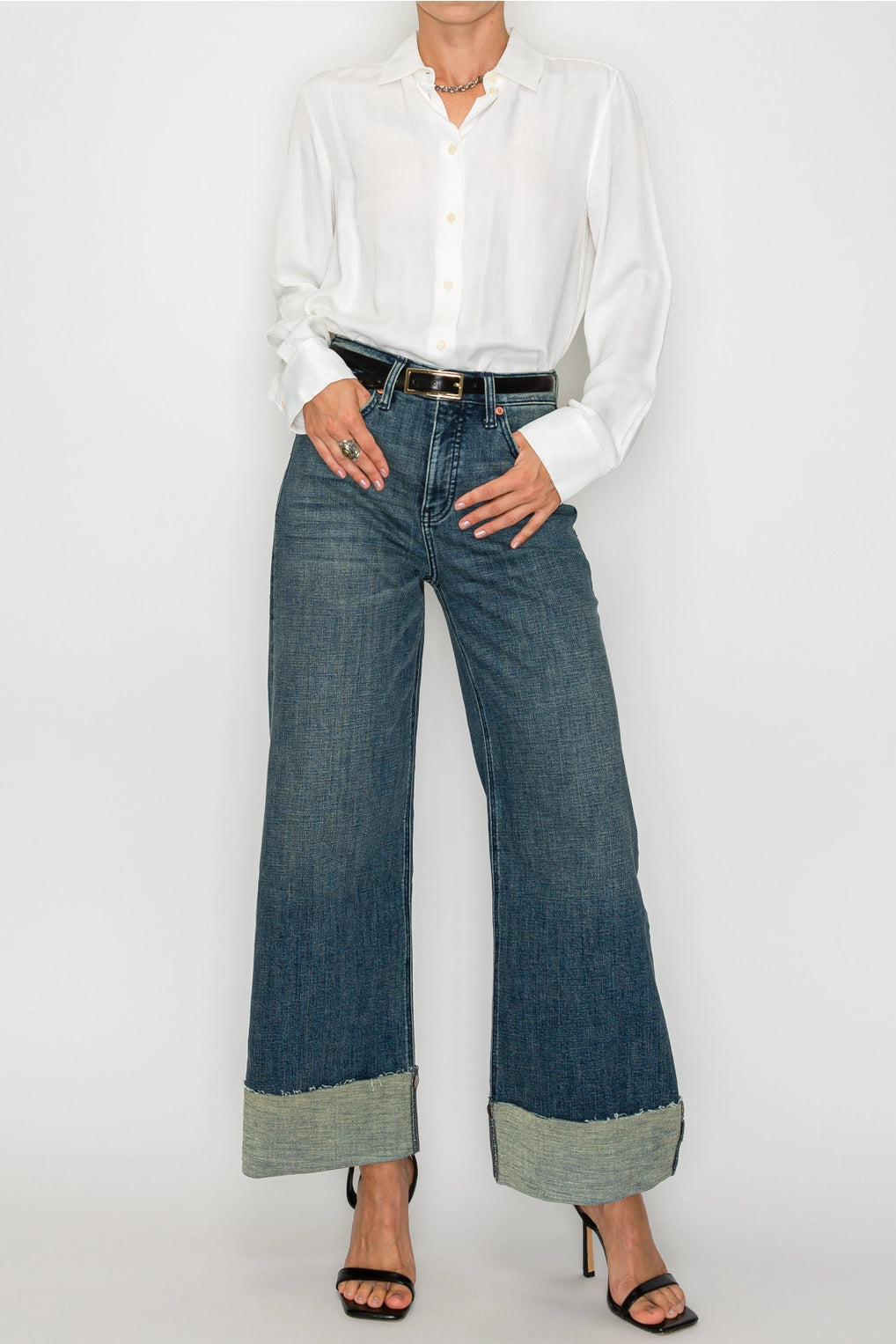 Front view — dark-wash high-rise wide-leg jeans with extra-wide cuffed hems and raw edge, 5-pocket style on model.