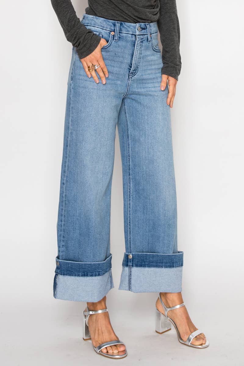 Model wearing ultra high-rise wide-leg jeans in medium stone wash with 5-inch cuff detail, styled with heels — modern cropped denim.