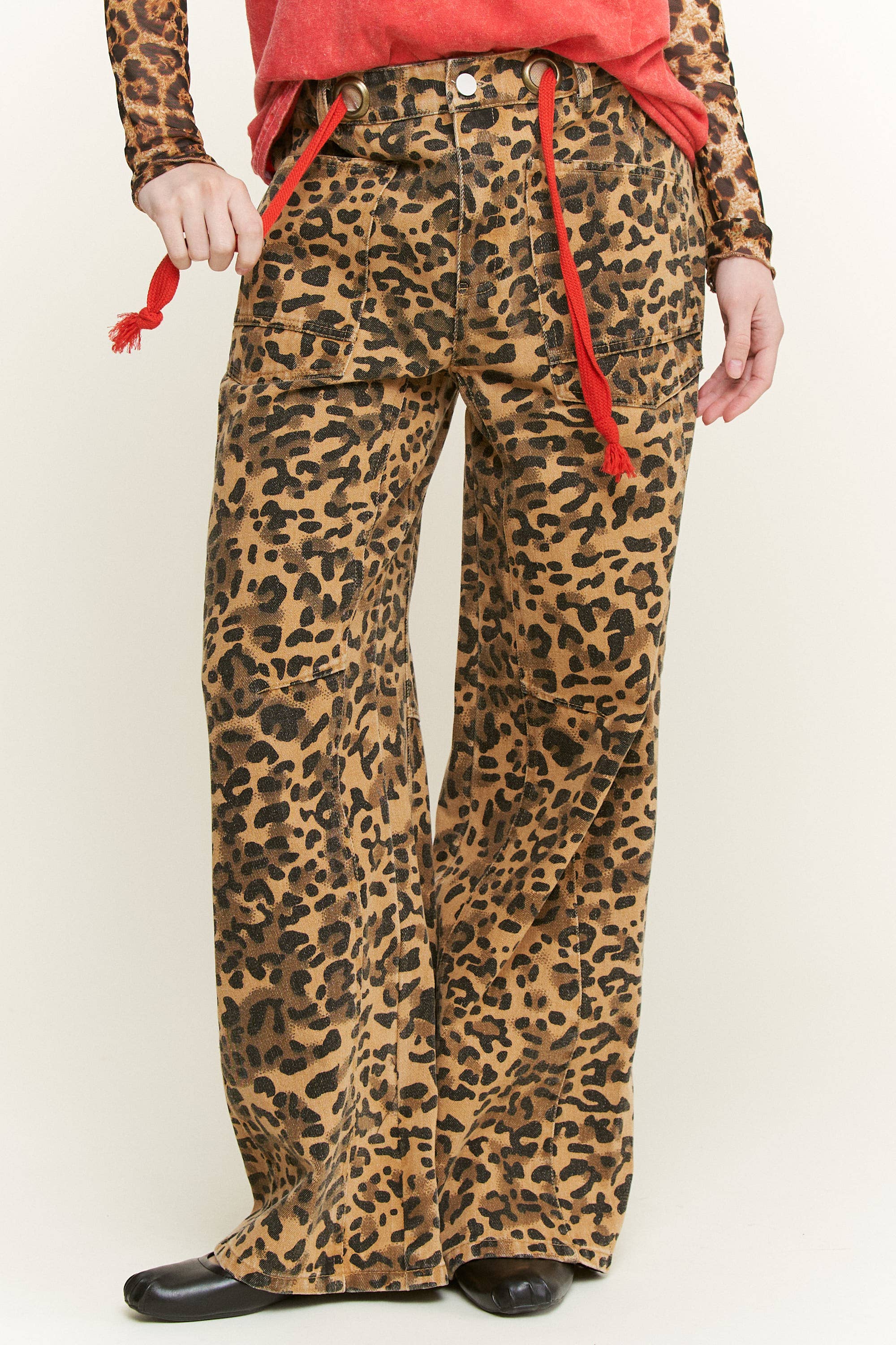 High-rise leopard-print wide-leg pants with front patch pockets and red rope belt ties, women’s utility style—front detail.
