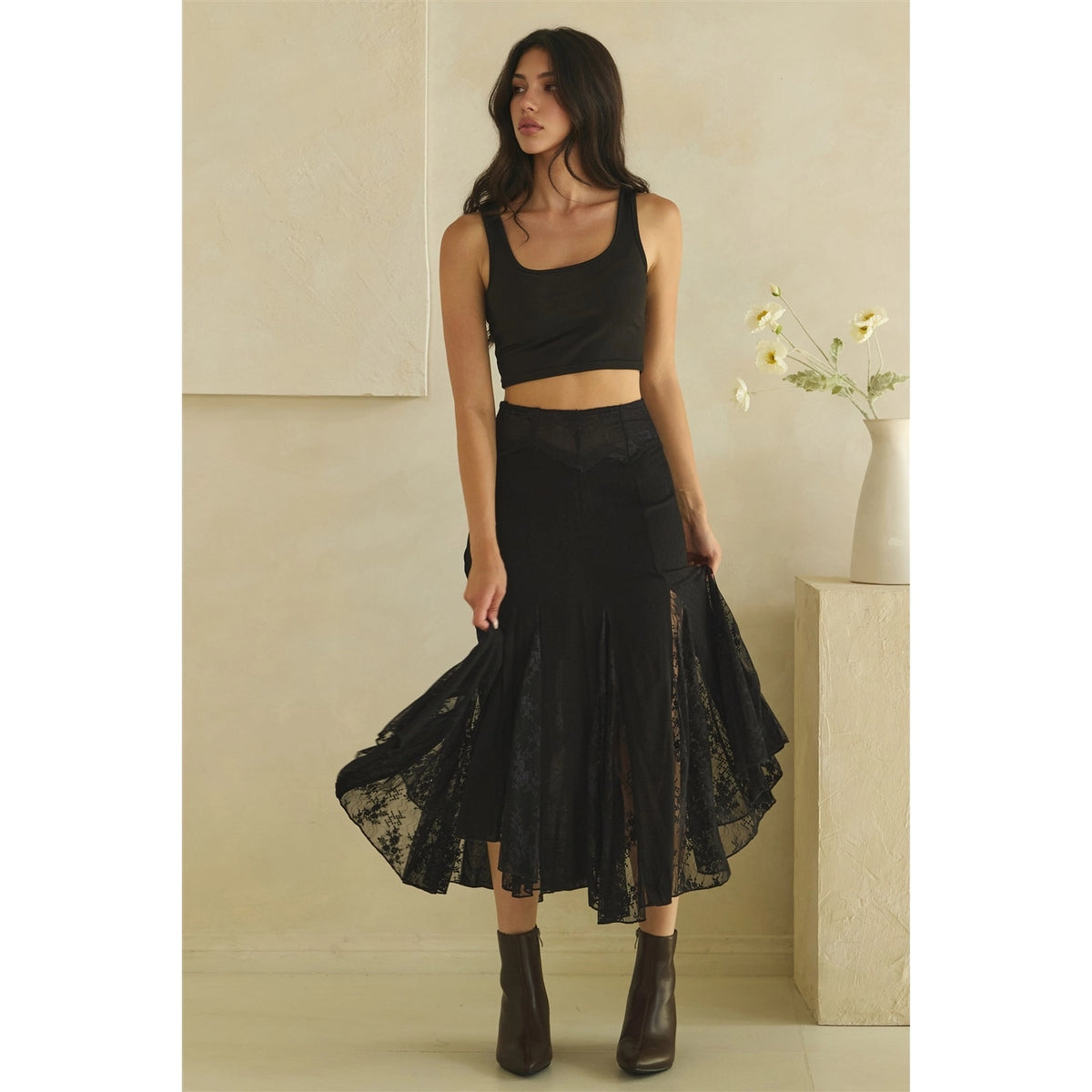 Calla Lace Godet Maxi Skirt in Black by Oli & Hali — full length front view on model, black satin and floral lace godet midi skirt with asymmetric hem, styled with black crop top and black ankle boots
