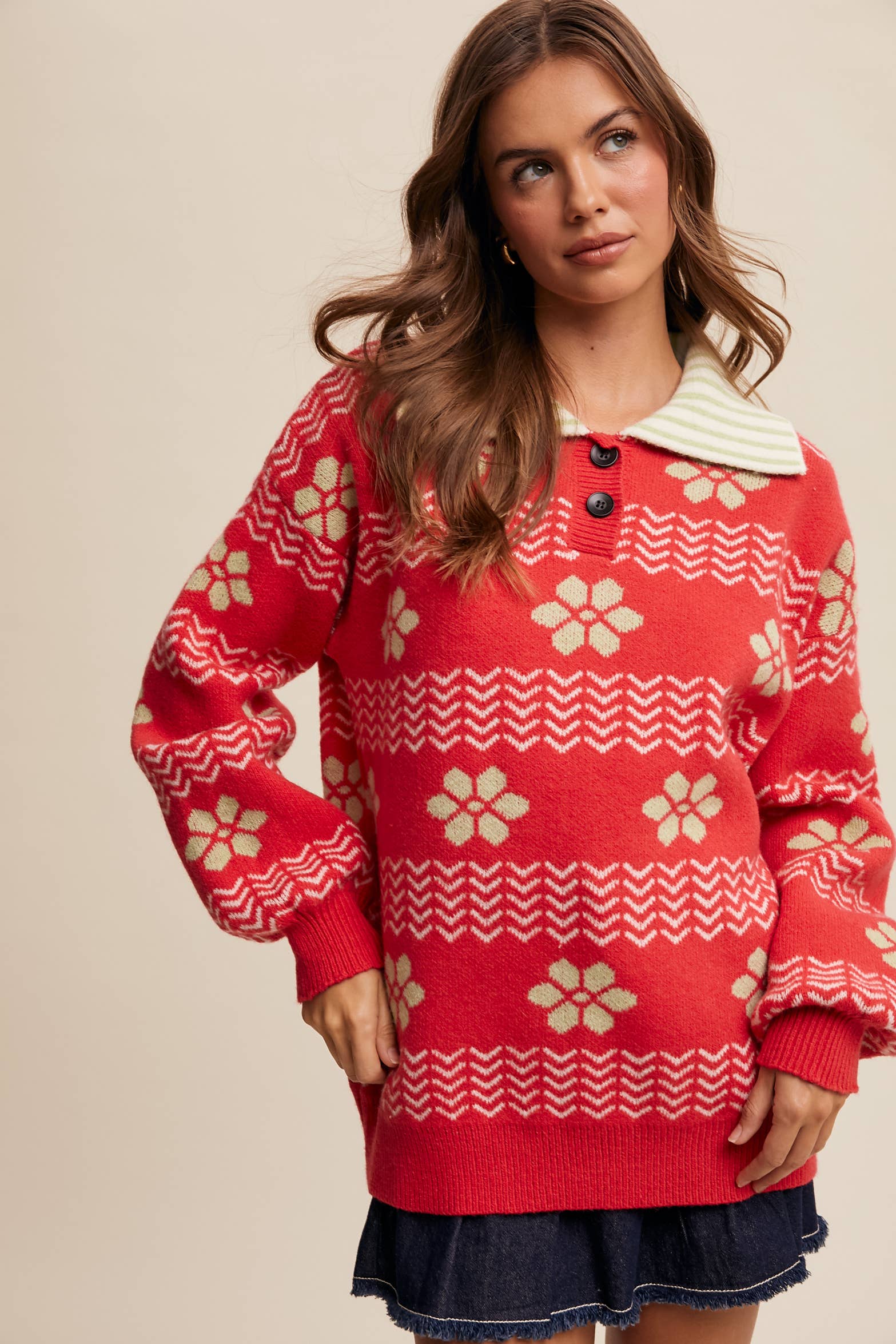 Woman wearing a red patterned sweater against a beige background