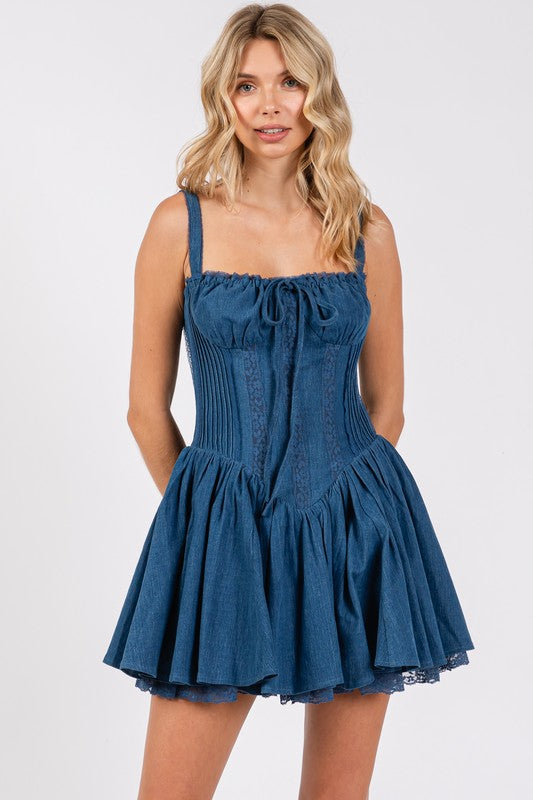 Blue denim corset mini dress with straps, ruched neckline, fitted bodice, and flared ruffle skirt with lace-trim hem.
