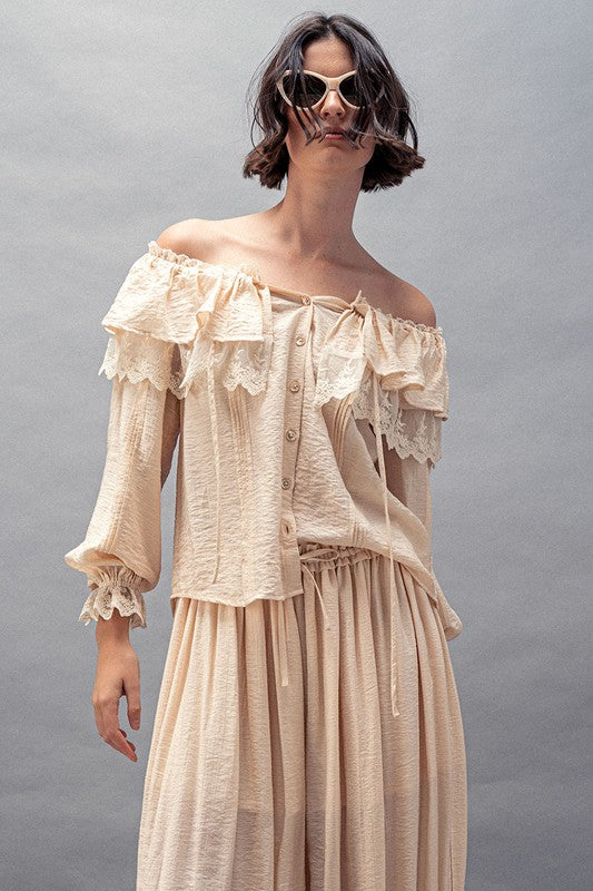Close up of Cream boho lace ruffle off-shoulder blouse with button-down front and billowy sleeves
