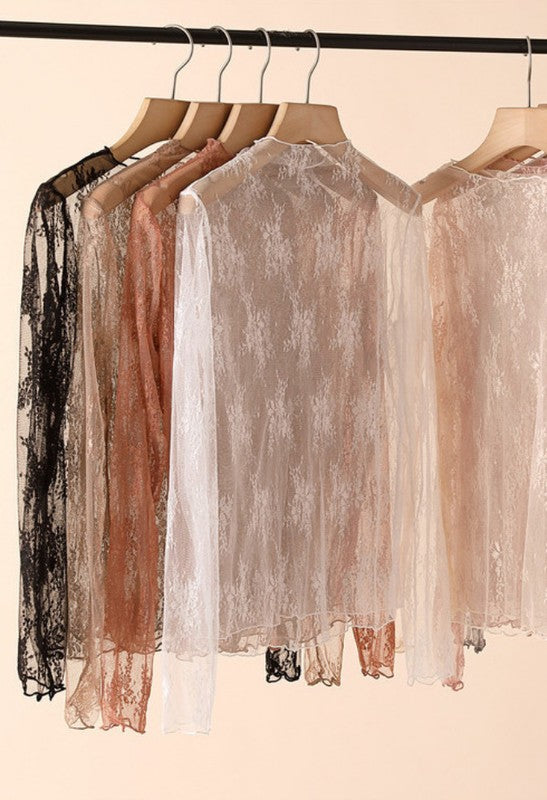 Stack of lace sleeveless tops in assorted colors including black, taupe, rust, white, pink, gray, and beige, folded neatly on a flat surface.