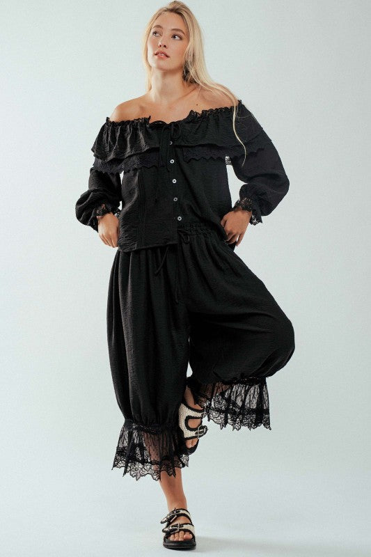 Model wearing black off-shoulder lace ruffle blouse styled with denim — Spirit & Wind Boutique
