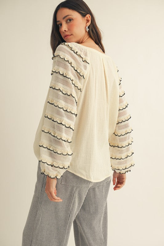 Back view of cream gauze peasant blouse with embroidered scalloped balloon sleeves and relaxed fit.