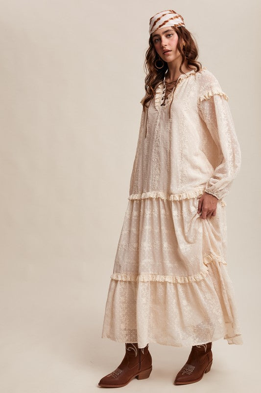 Side view of model in ivory lace boho maxi dress with ruffle tiers, headscarf, and brown western boots.