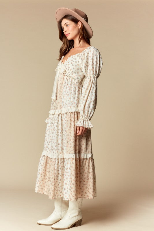 Side view — cream/blush ditsy floral tiered maxi dress with ruffle trim, long puff sleeves, tie-front sweetheart neckline.