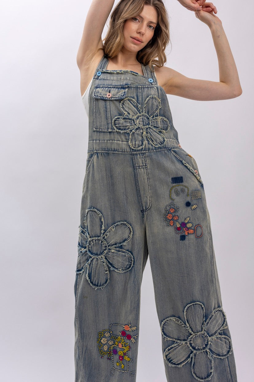 wide-leg denim overalls, daisy appliqué patches, colorful floral embroidery, front view