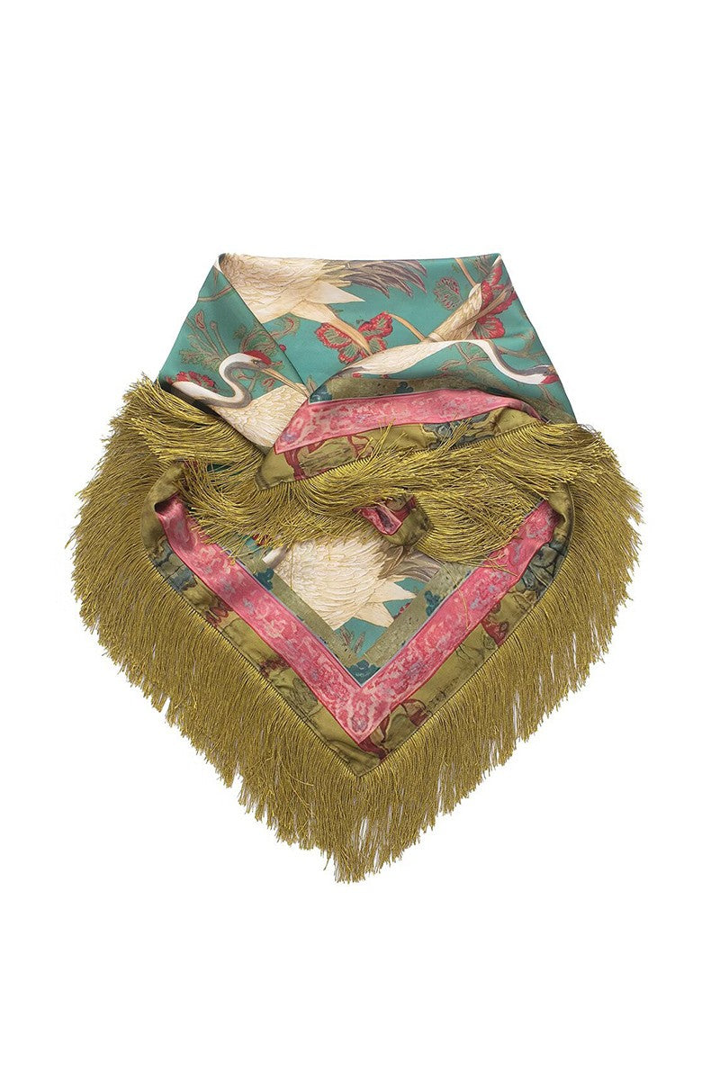 A square fringed scarf featuring a teal background with a white crane print, layered with pink patterned trim and a prominent olive green fringed border.