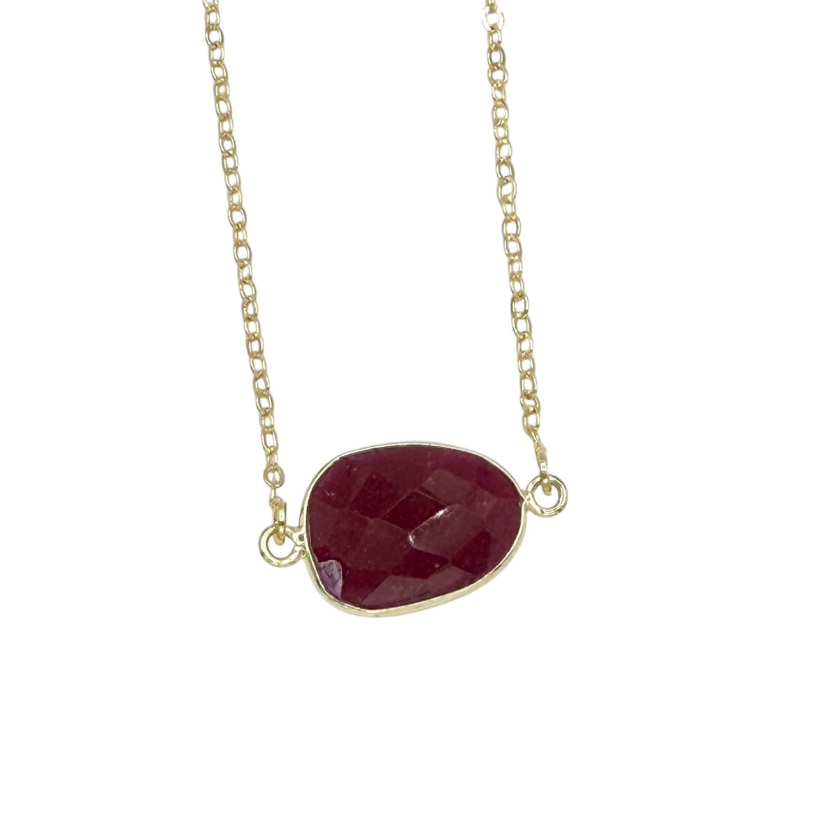 Necklace with a red teardrop-shaped pendant on a gold chain against a white background