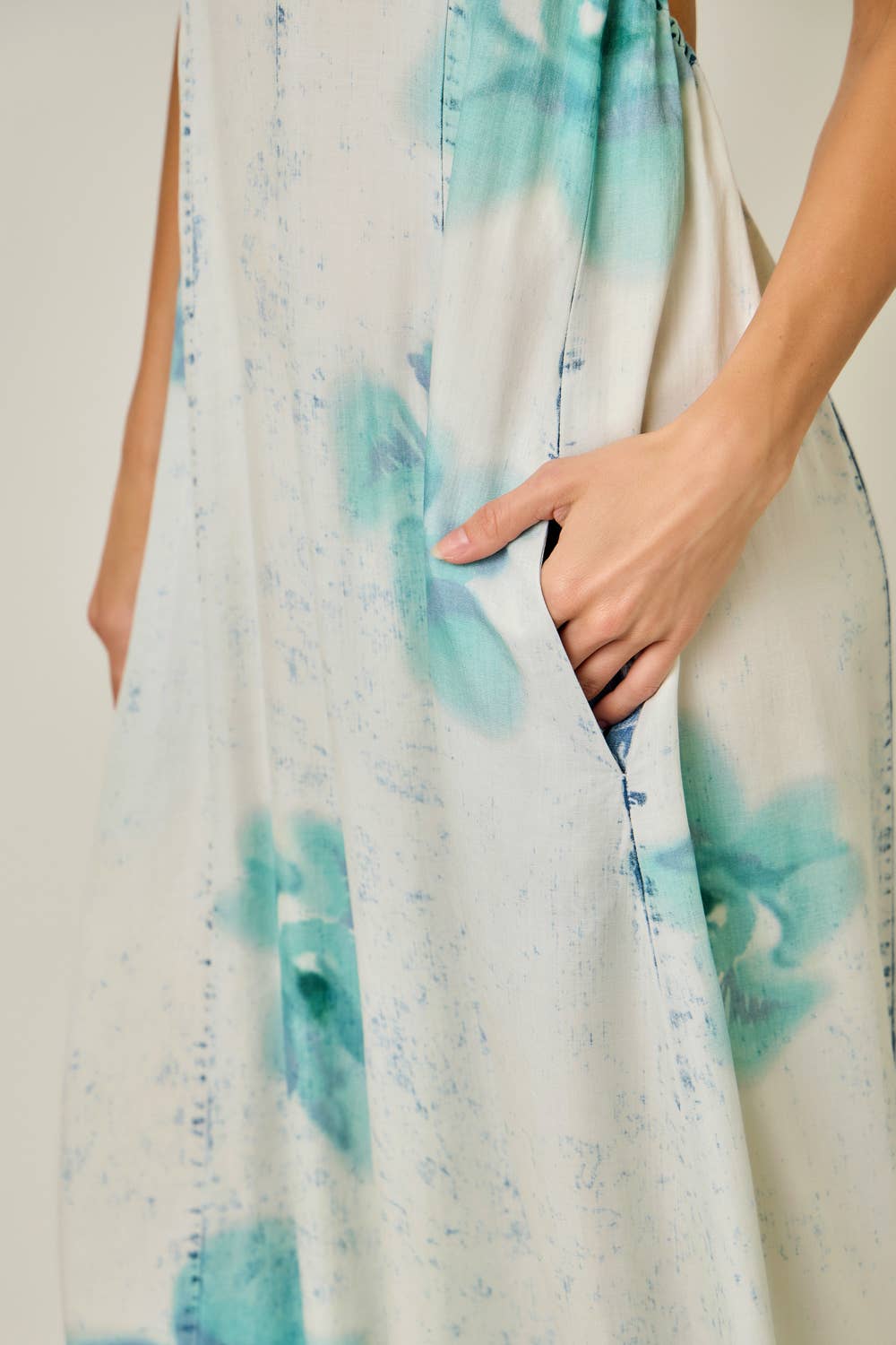 Close-up of a jumpsuitwith blue watercolor patterns on a plain background