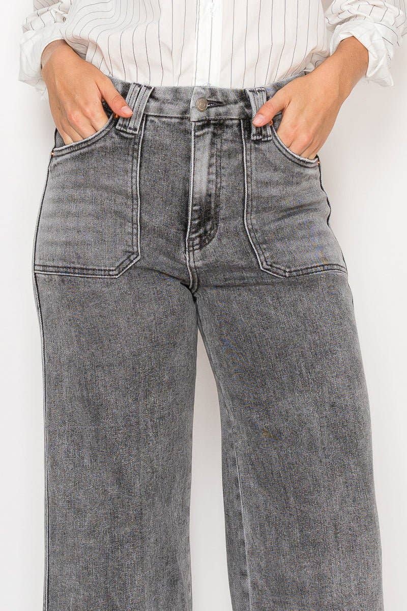 Person wearing gray high-waisted jeans with a white background