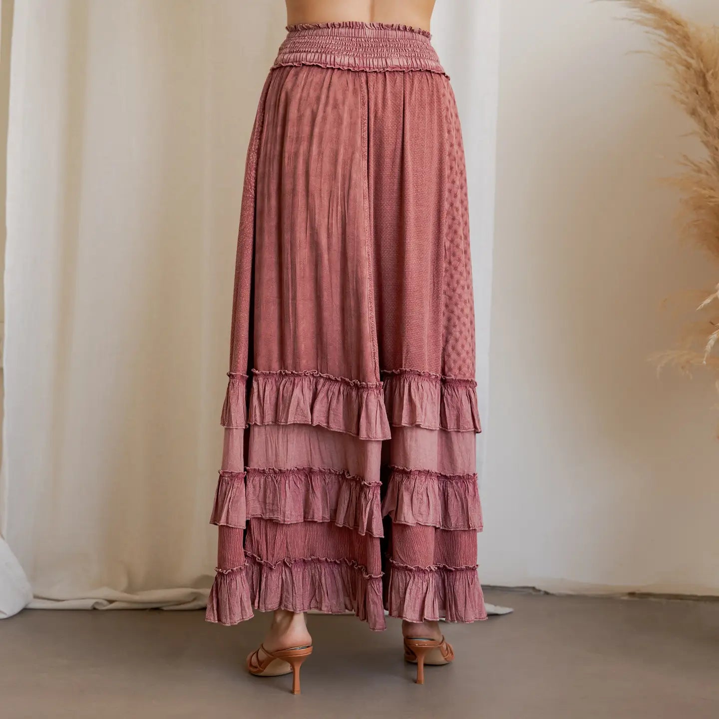 Garnet Artisan Panel Maxi Skirt - back view showing smocked waist, textured panels, and layered ruffle hem styled with strappy heels