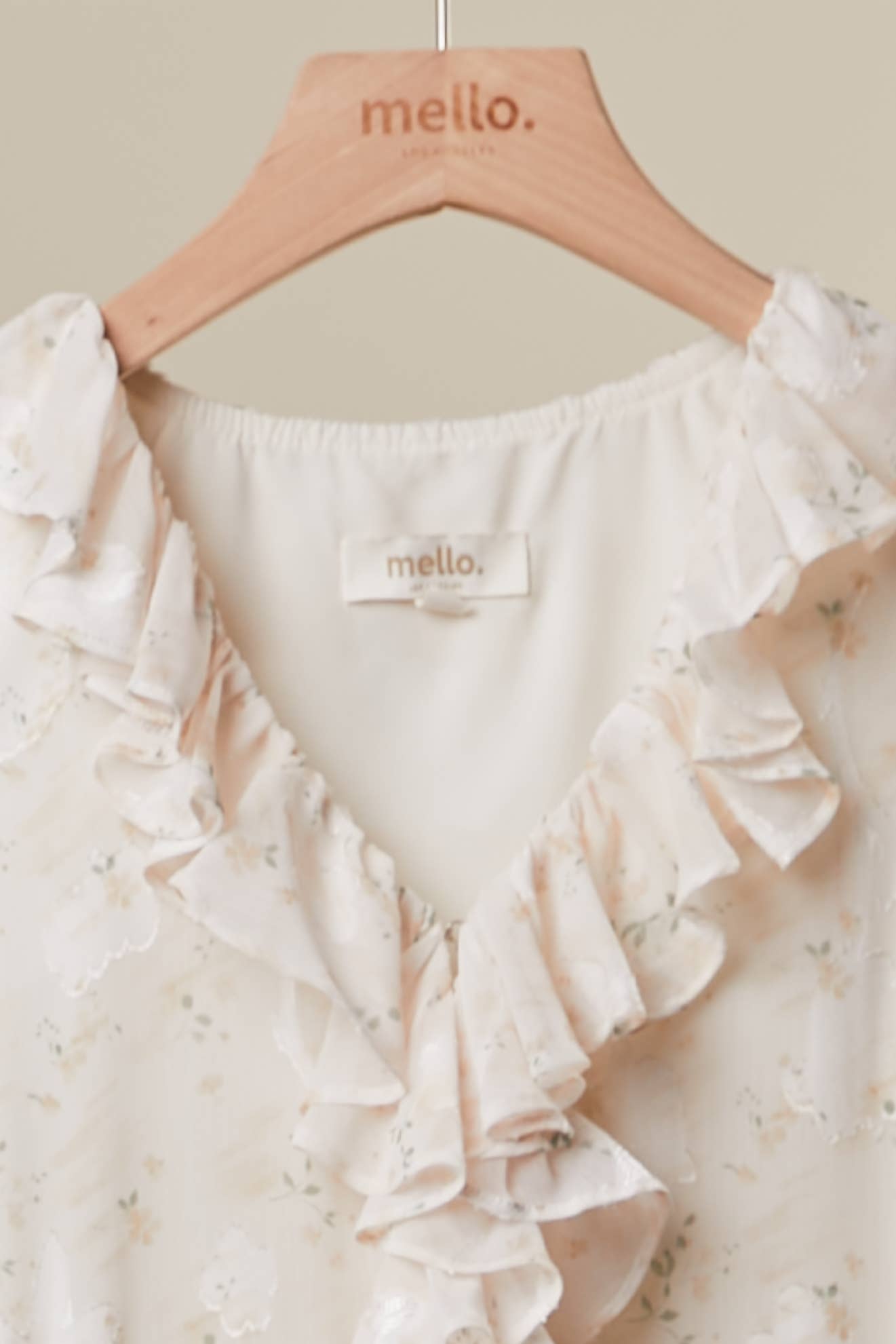 Elegant floral tunic detail - close-up of romantic ruffled accents and lightweight flowing fabric