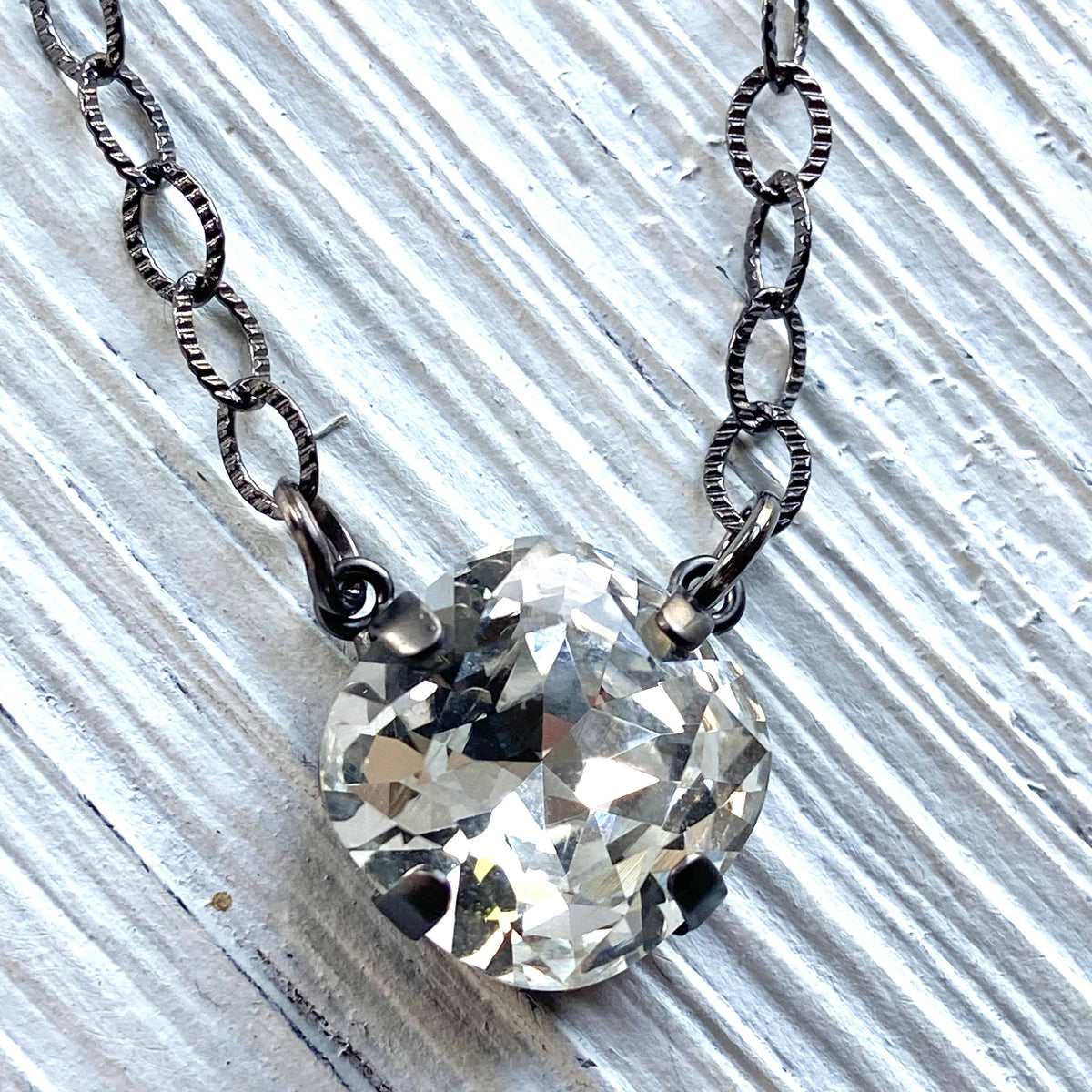 Necklace with a large crystal pendant on a textured white background
