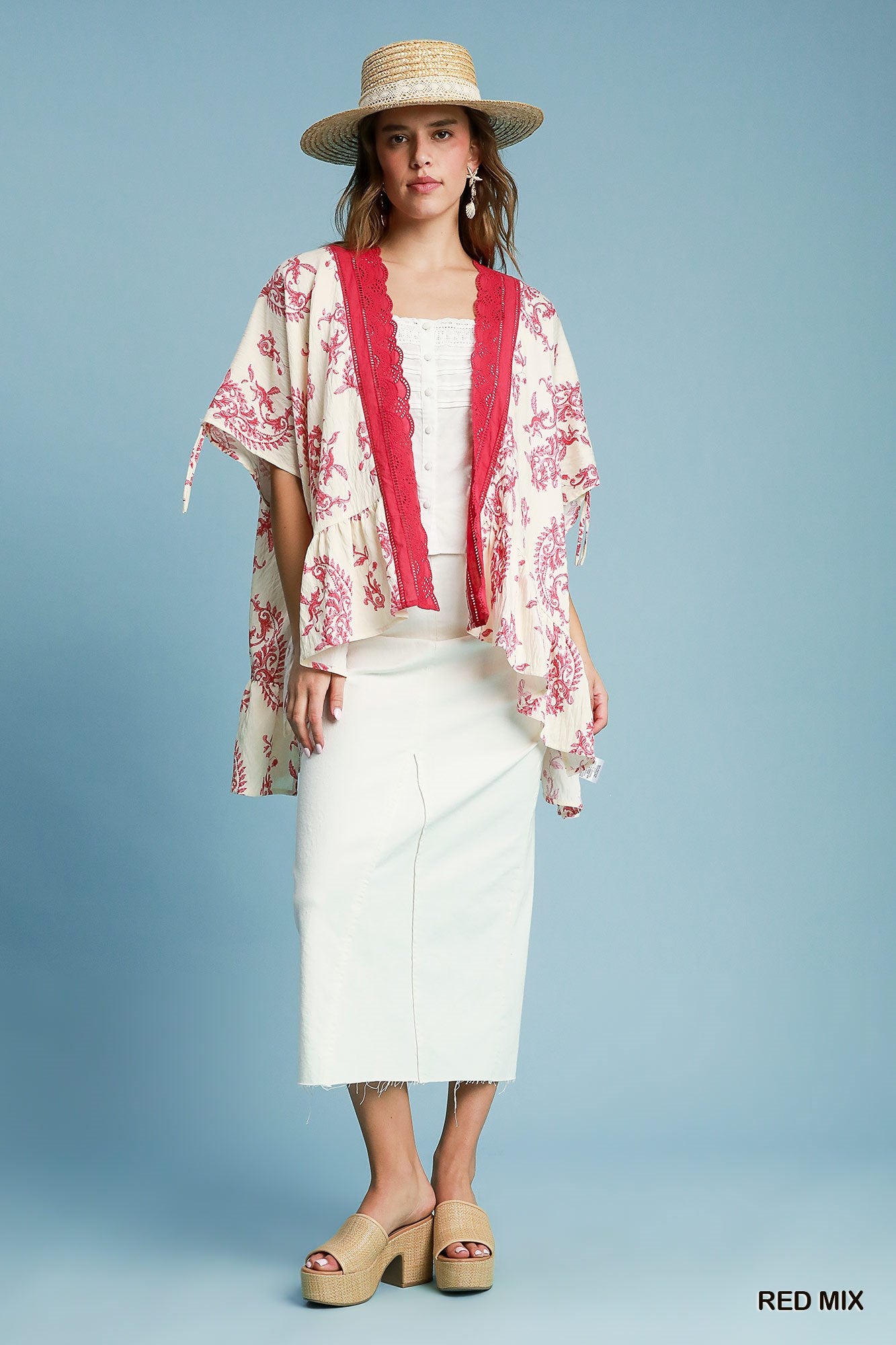 Woman wearing a red and white patterned kimono over a white outfit against a blue background