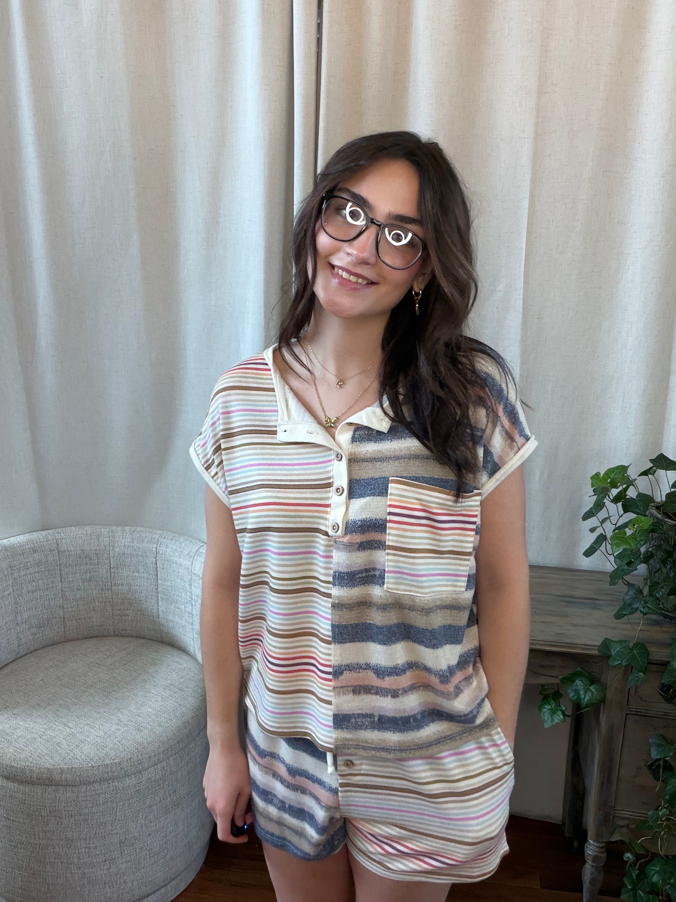 Woman wearing a striped shirt and shorts set in a home setting.
