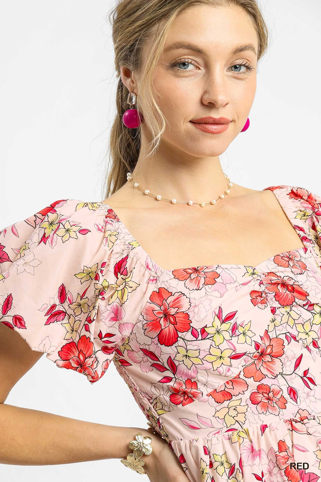 Woman wearing a floral dress with a plain background