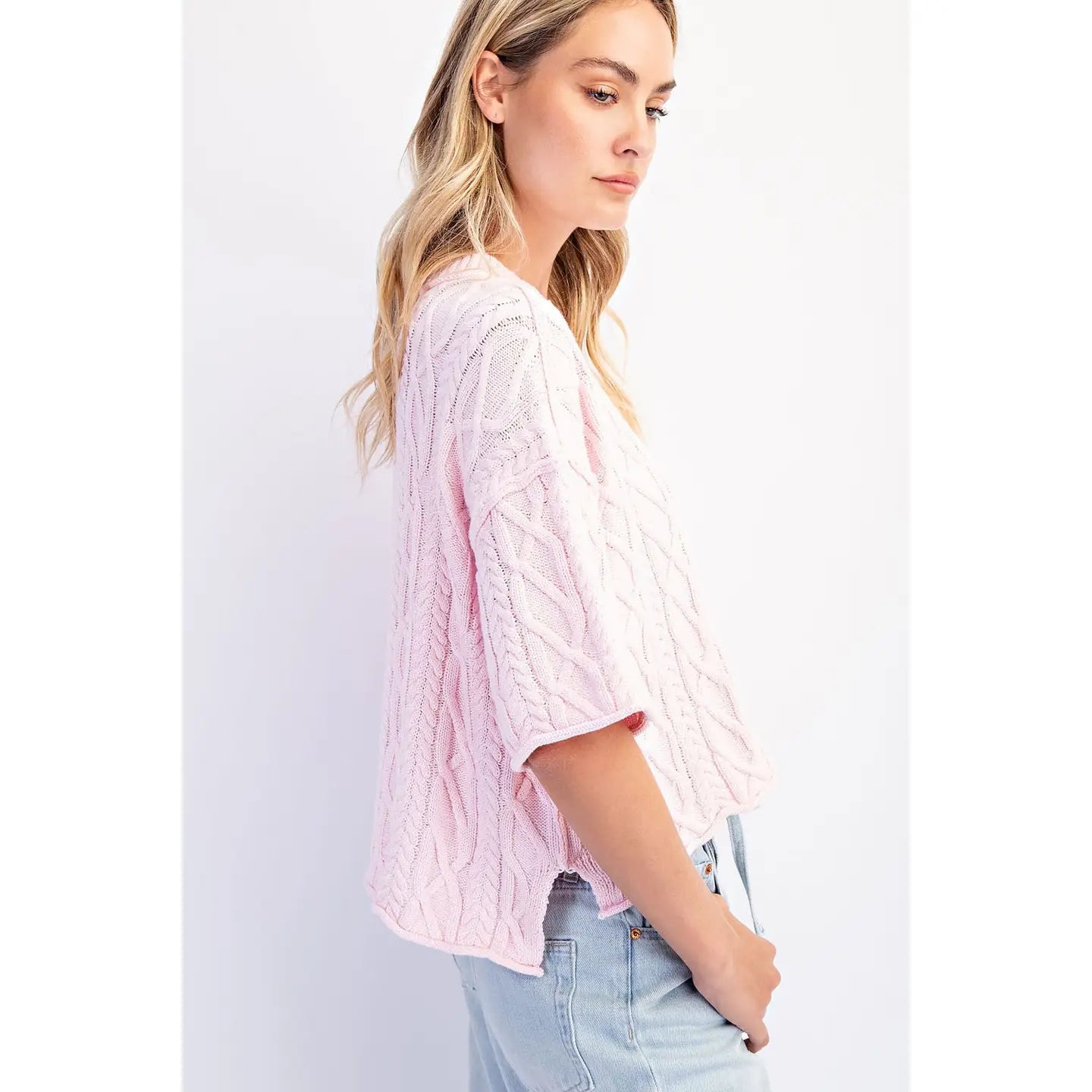 Side view of The Cove Oversized Sweater in Baby Pink — front view, slouchy cable knit with dropped shoulders and asymmetrical hem in Pink
