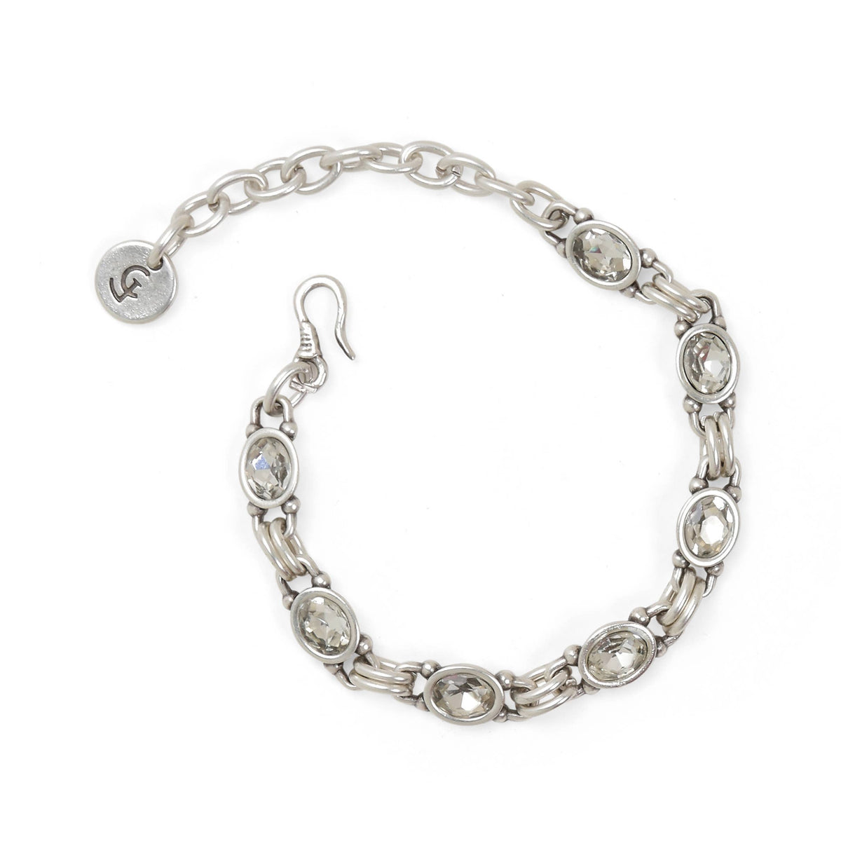 A silver-toned chain bracelet with oval clear rhinestone accents, a fishhook clasp, and a small round branded tag on a plain white background.