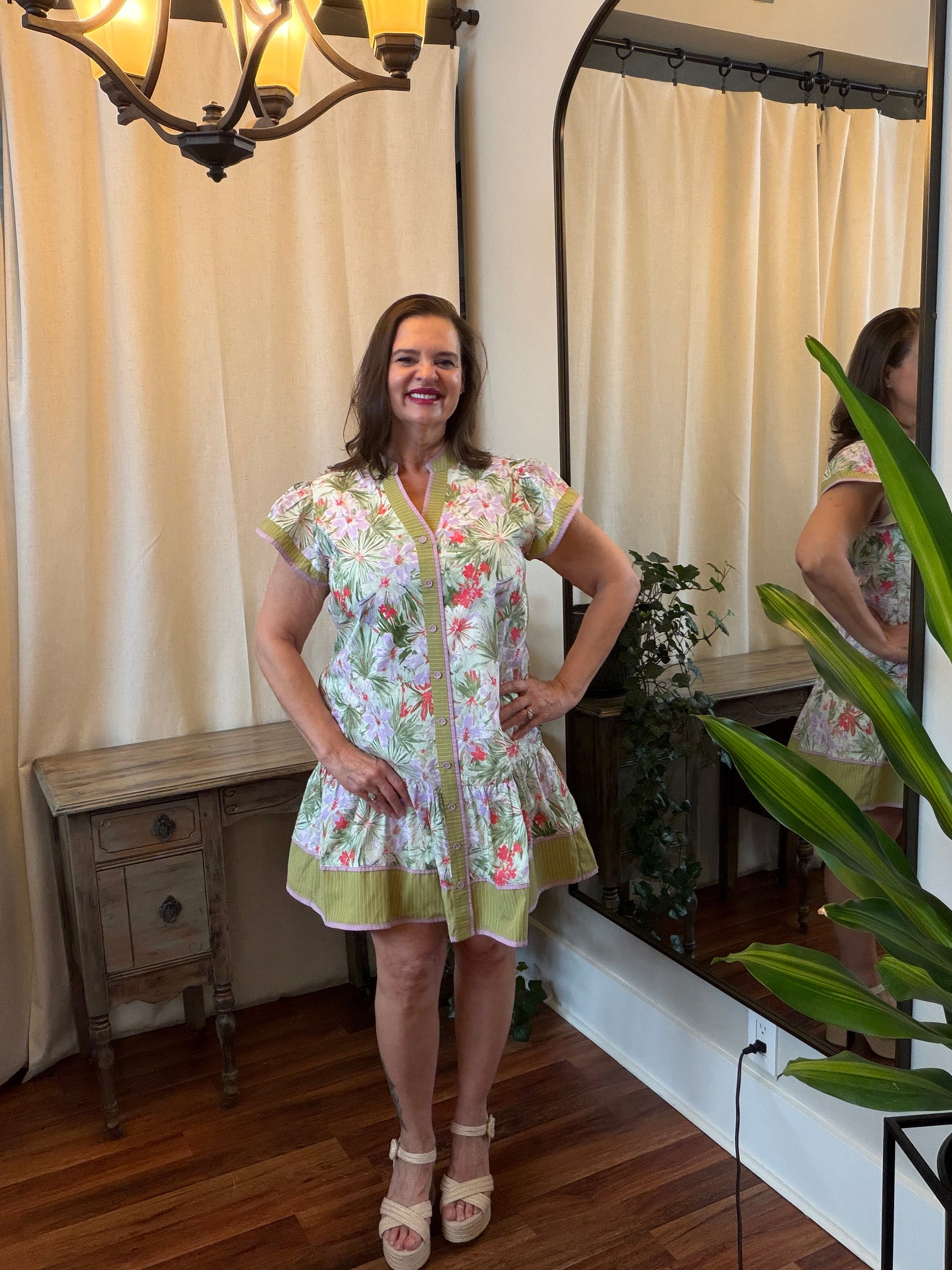 Tropical Floral Tiered Dress - front view showing button-front closure, flutter sleeves, striped contrast neckline trim, and tropical floral tiered skirt
