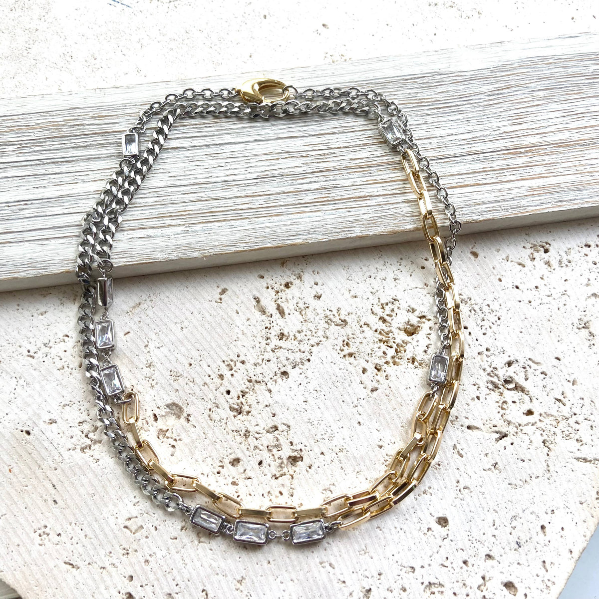 Necklace with chain and gemstone accents on a textured surface