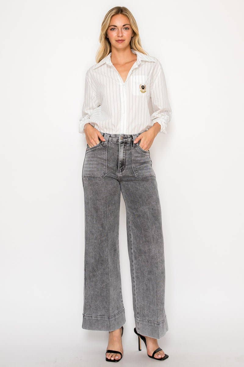 Woman wearing a white blouse and gray jeans on a white background
