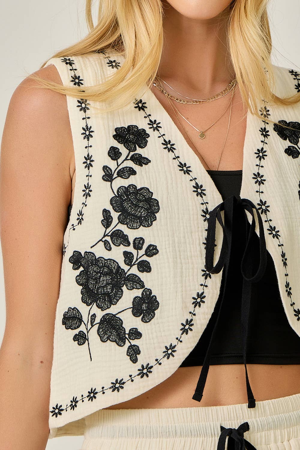 Close up of  Embroidered Cotton Gauze Tie-Front Vest in Ivory — open front with tie, V-neckline, and delicate embroidery detail

