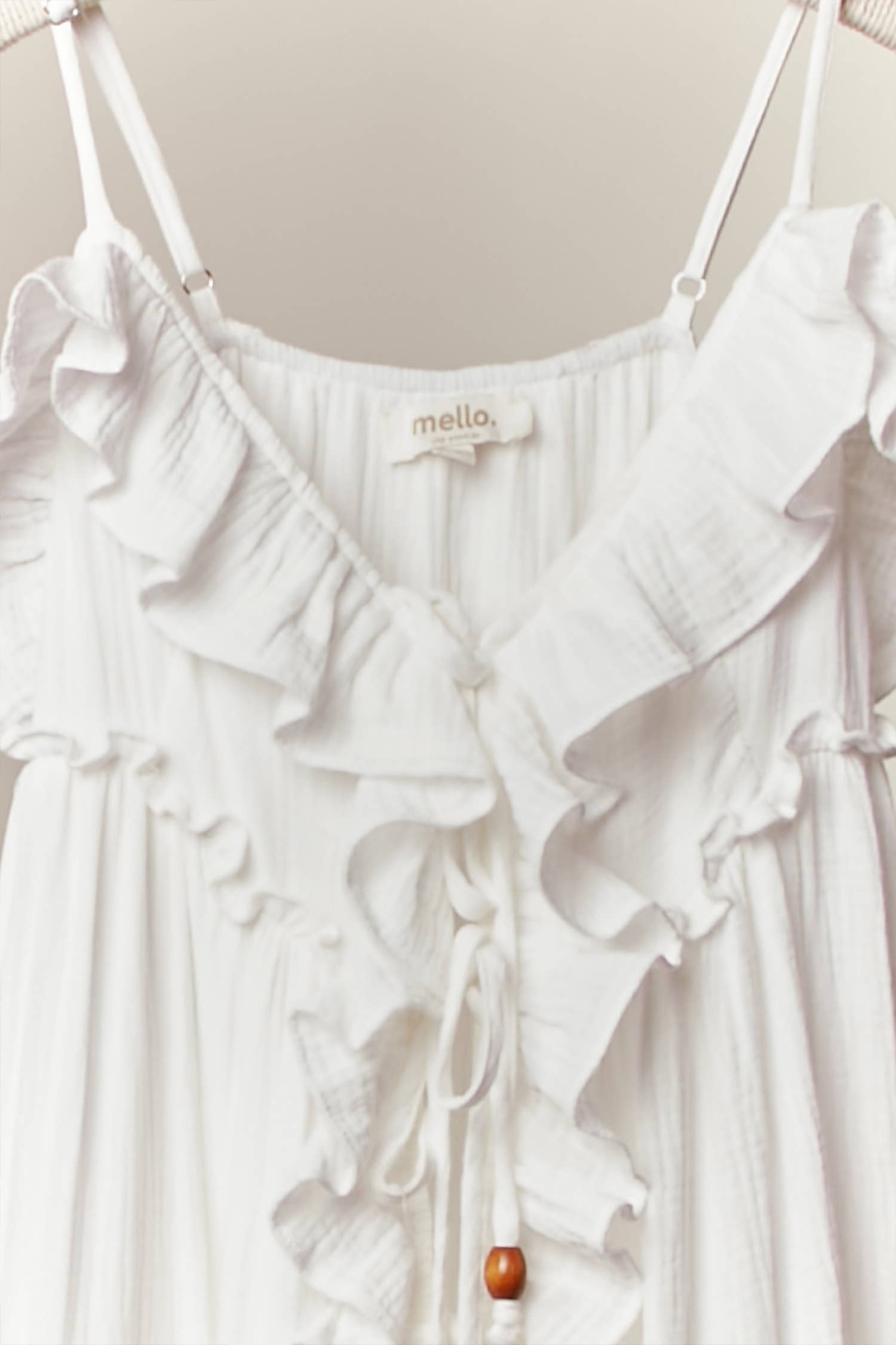 Cream ruffle cardigan dress detail - close-up of luxurious flowing fabric and cascading ruffle construction