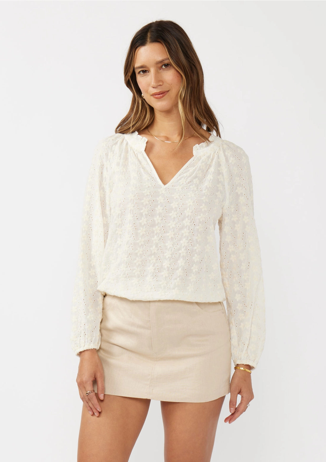 Woman wearing a white blouse and beige skirt on a white background