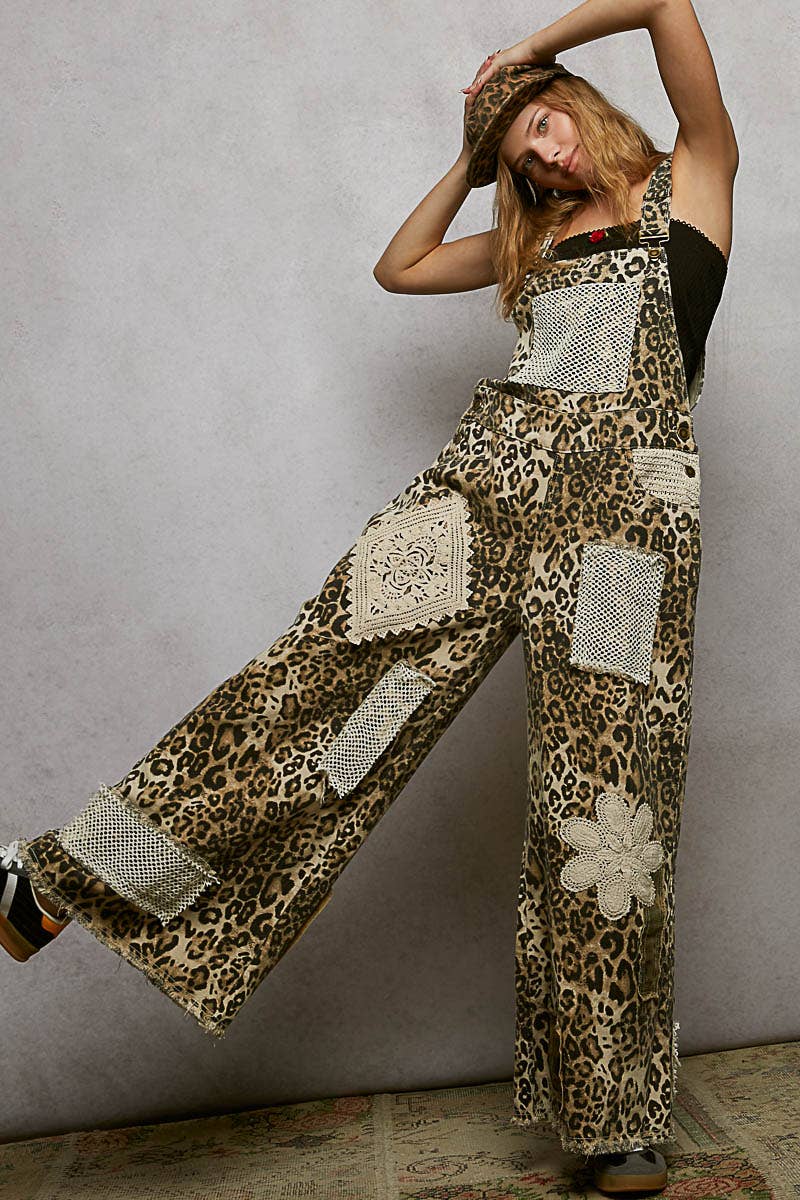 Boho leopard print patchwork overalls featuring wide legs, crochet lace appliqué details, and distressed accents. Styled with a leopard hat and black crop top for a trendy, eclectic look.