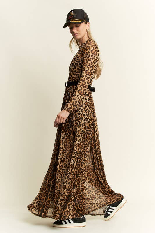Side view of a leopard-print long-sleeve mesh maxi dress with a sheer, flowy skirt, styled with a black belt, baseball cap, and black-and-white sneakers.