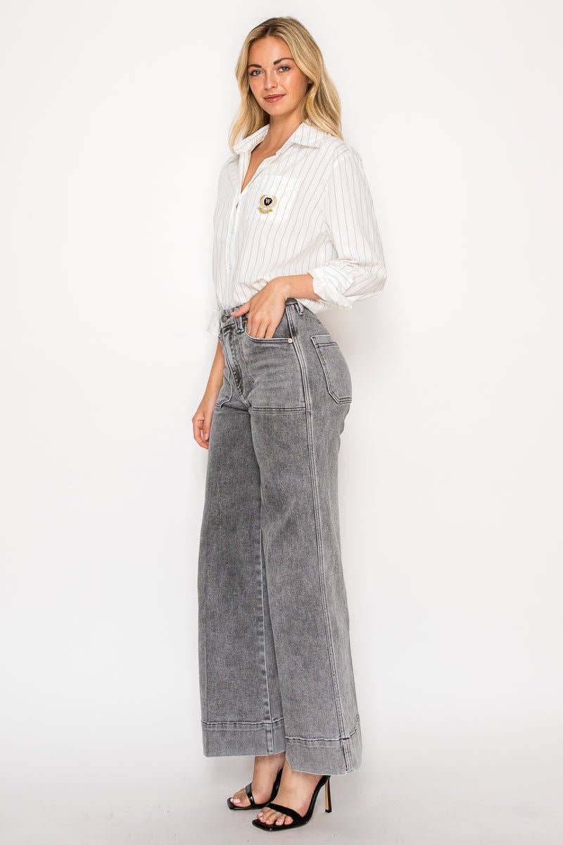 Woman wearing a white blouse and gray wide-leg pants on a white background